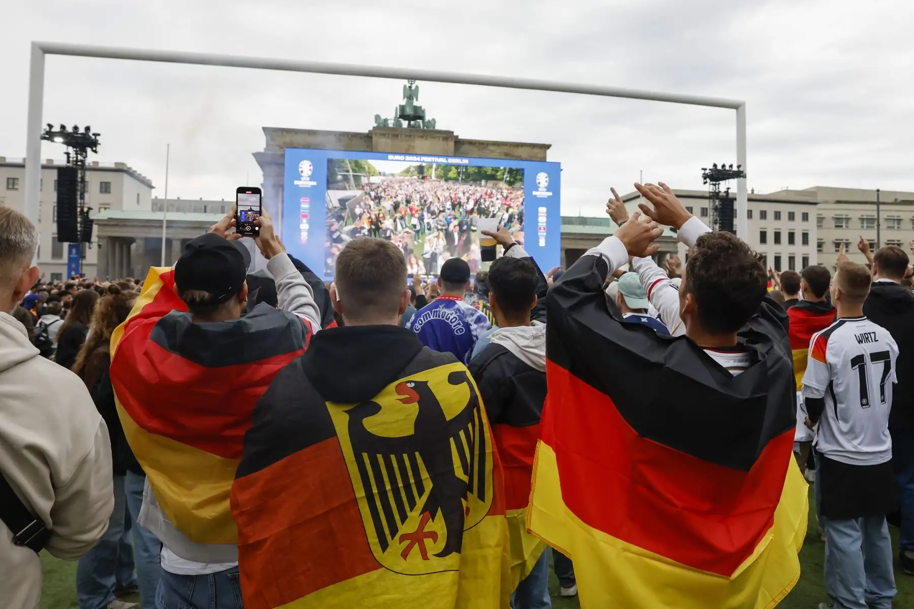 La afición alemana anima a su selección de fútbol hoy viernes en la Puerta de Brandeburgo, en Berlín, durante el partido inaugural de la Eurocopa 2024 que juegan los combinados nacionales de Alemania y Escocia. Foto: ANDINA/EFE