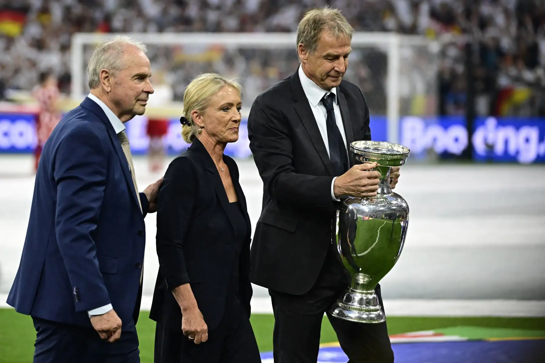 La viuda del fallecido internacional alemán, Franz Beckenbauer, Heidi Beckenbauer, el ex internacional alemán Bernard Dietz y el ex internacional alemán Jürgen Klinsmann llevan la Copa Henri Delaunay al campo en la ceremonia de apertura antes del grupo de la UEFA Euro 2024. Un partido de fútbol entre Alemania y Escocia en el Munich Football Arena de Múnich el 14 de junio de 2024. Foto: AFP