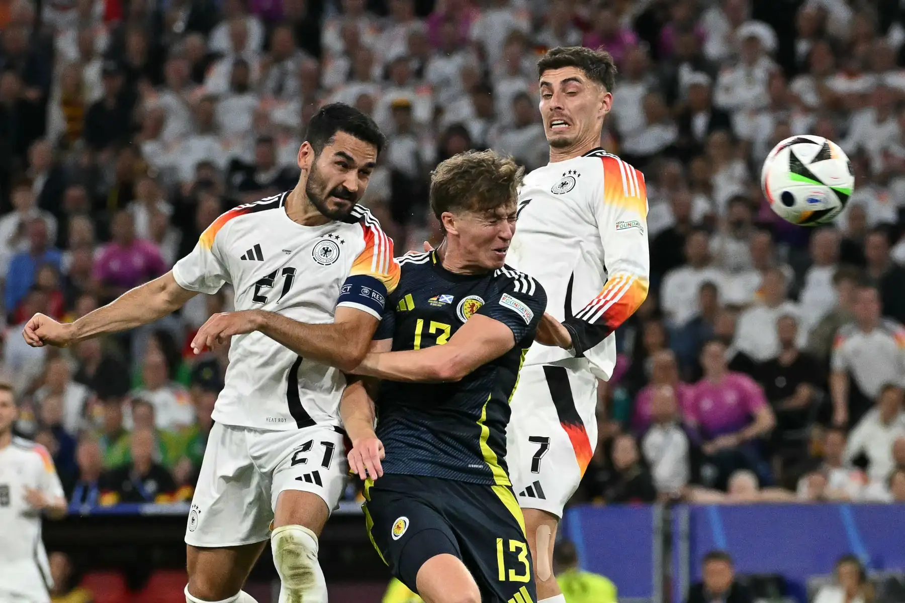 El defensor escocés #13 Jack Hendry (C) lucha por el balón con el centrocampista alemán #21 Ilkay Gundogan (L) y el delantero alemán #07 Kai Havertz durante el partido de fútbol del Grupo A de la UEFA Euro 2024 entre Alemania y Escocia en el Munich Football Arena en Munich el 14 de junio de 2024. Foto: AFP