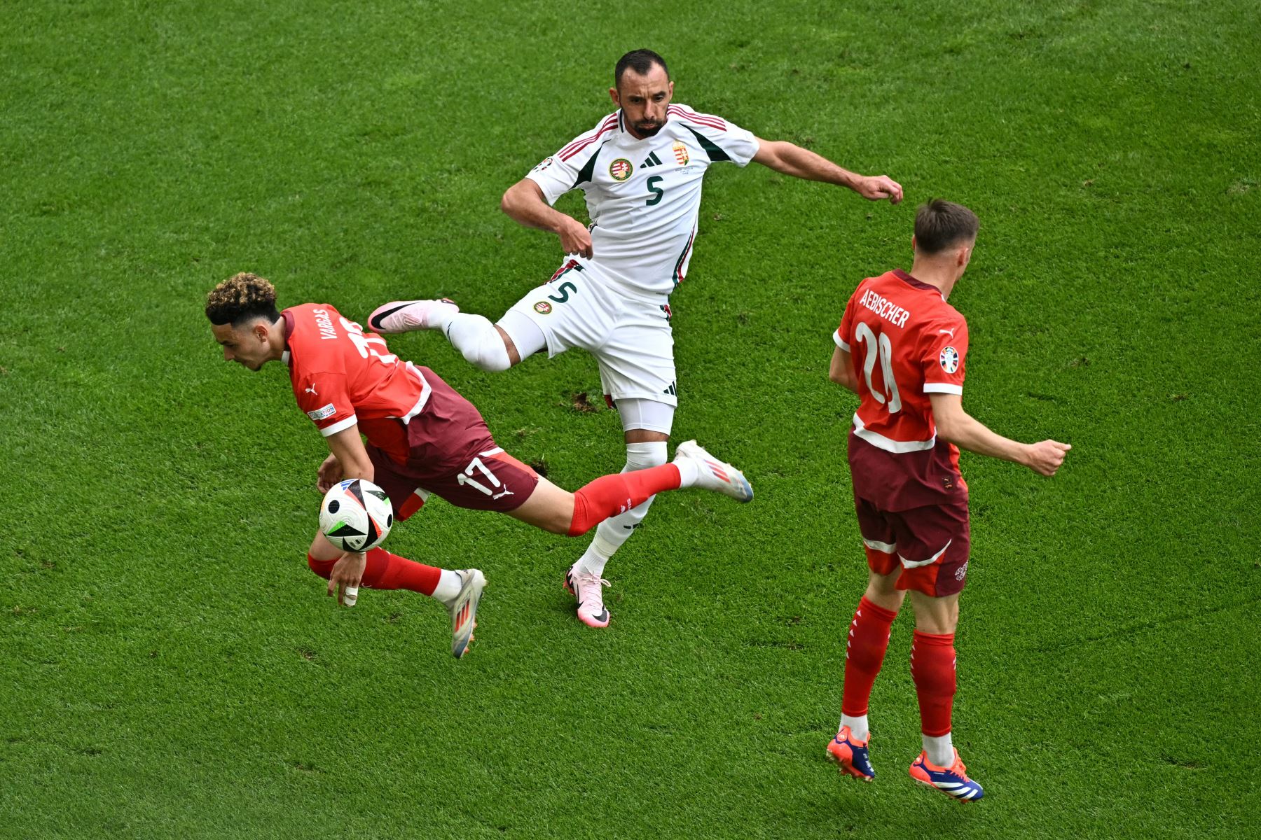 El defensor húngaro #05 Attila Fiola (C) lucha por el balón con el centrocampista suizo #17 Ruben Vargas (L) y el centrocampista suizo #20 Michel Aebischer durante el partido de fútbol de la UEFA Euro 2024 Grupo A entre Hungría y Suiza en el estadio de Colonia en Colonia. Foto: AFP