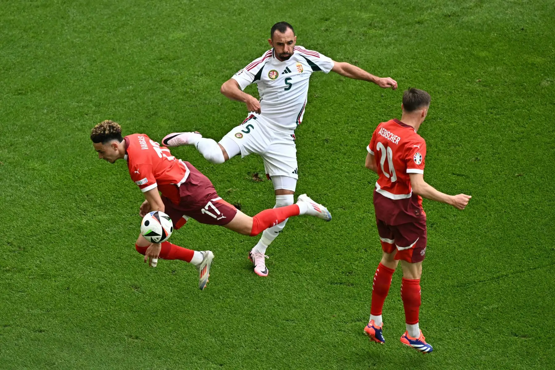 El defensor húngaro #05 Attila Fiola (C) lucha por el balón con el centrocampista suizo #17 Ruben Vargas (L) y el centrocampista suizo #20 Michel Aebischer durante el partido de fútbol de la UEFA Euro 2024 Grupo A entre Hungría y Suiza en el estadio de Colonia en Colonia. Foto: AFP