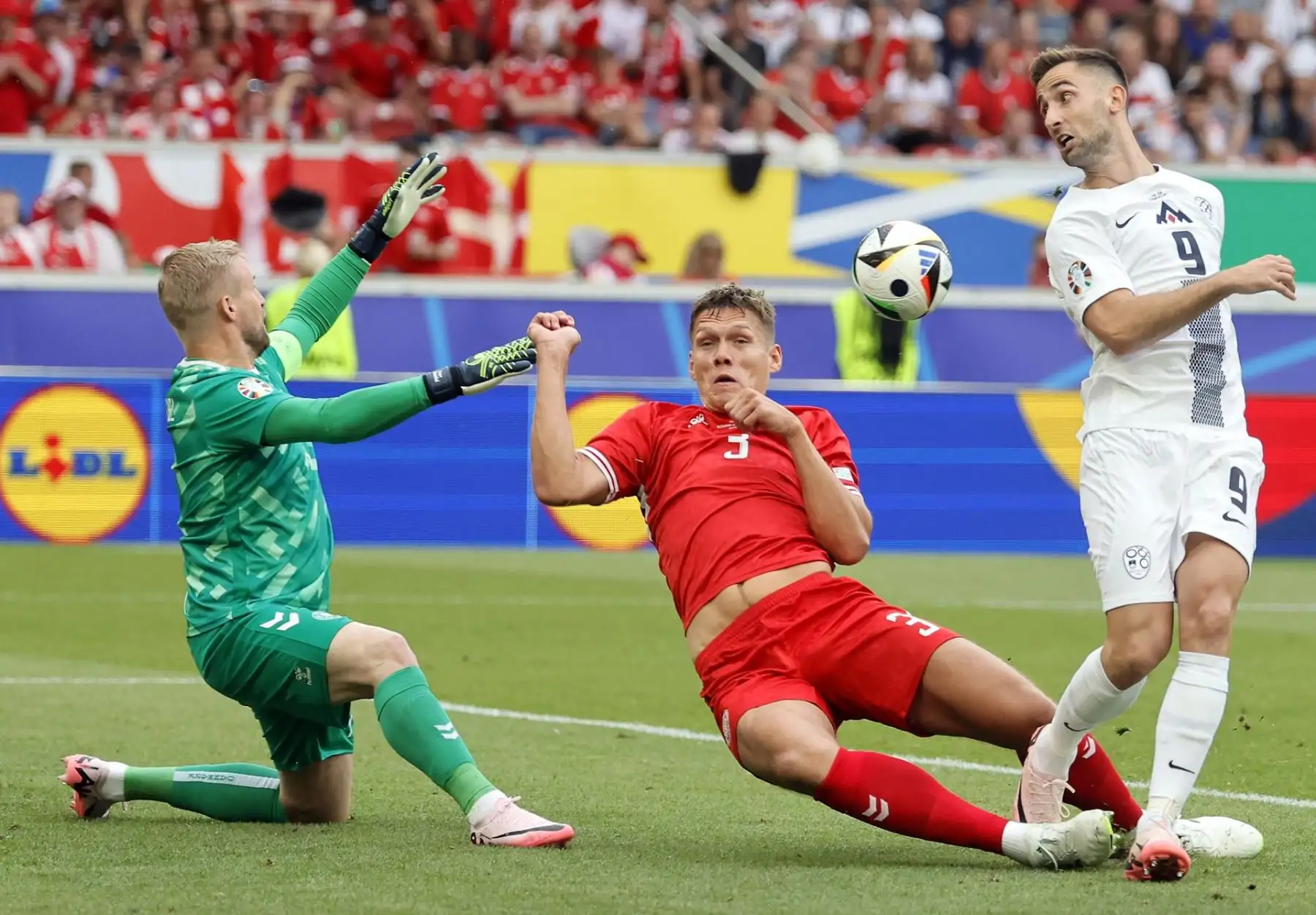 El portero Kasper Schmeichel de Dinamarca, Jannik Vestergaard de Dinamarca y Andraz Sporar de Eslovenia en acción durante el partido de fútbol del Grupo C de la UEFA EURO 2024 entre Eslovenia y Dinamarca. EFE