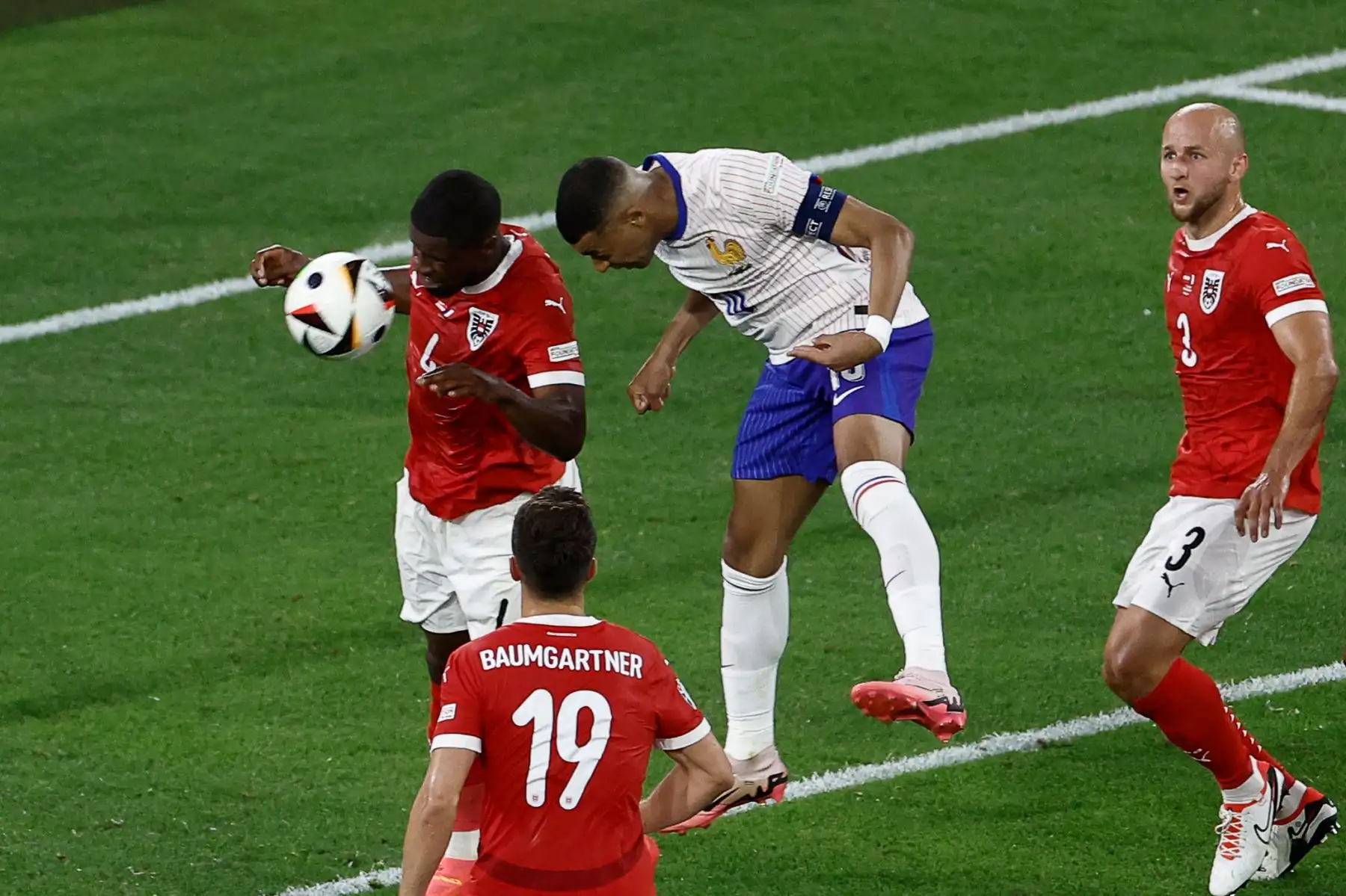 El defensa austriaco Kevin Danso lucha por el cabezazo con el delantero francés  Kylian Mbappé durante el partido de fútbol del Grupo D de la UEFA Euro 2024 entre Austria y Francia.  Foto: ANDINA/AFP