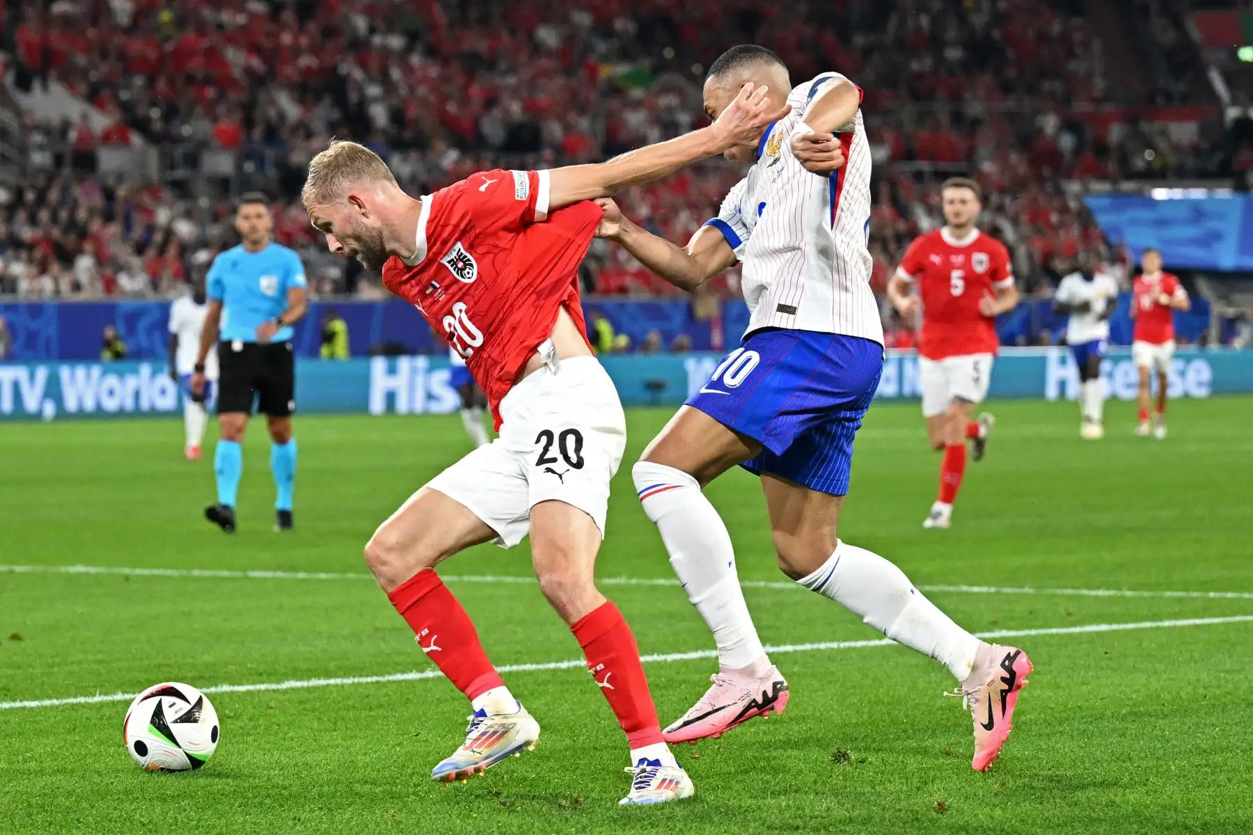 El centrocampista austriaco Konrad Laimer comete una falta contra el delantero francés Kylian Mbappé durante el partido de fútbol del Grupo D de la UEFA Euro 2024 entre Austria y Francia. 
Foto: ANDINA/AFP