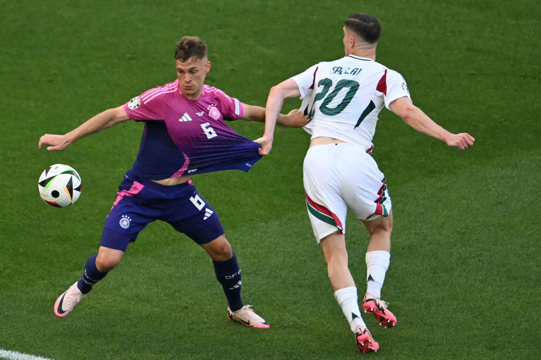 El defensor alemán Joshua Kimmich y el delantero húngaro, Roland Sallai luchan por el balón durante el partido de fútbol del Grupo A de la UEFA Euro 2024 entre Alemania y Hungría en el Stuttgart Arena de Stuttgart.
Foto: AFP