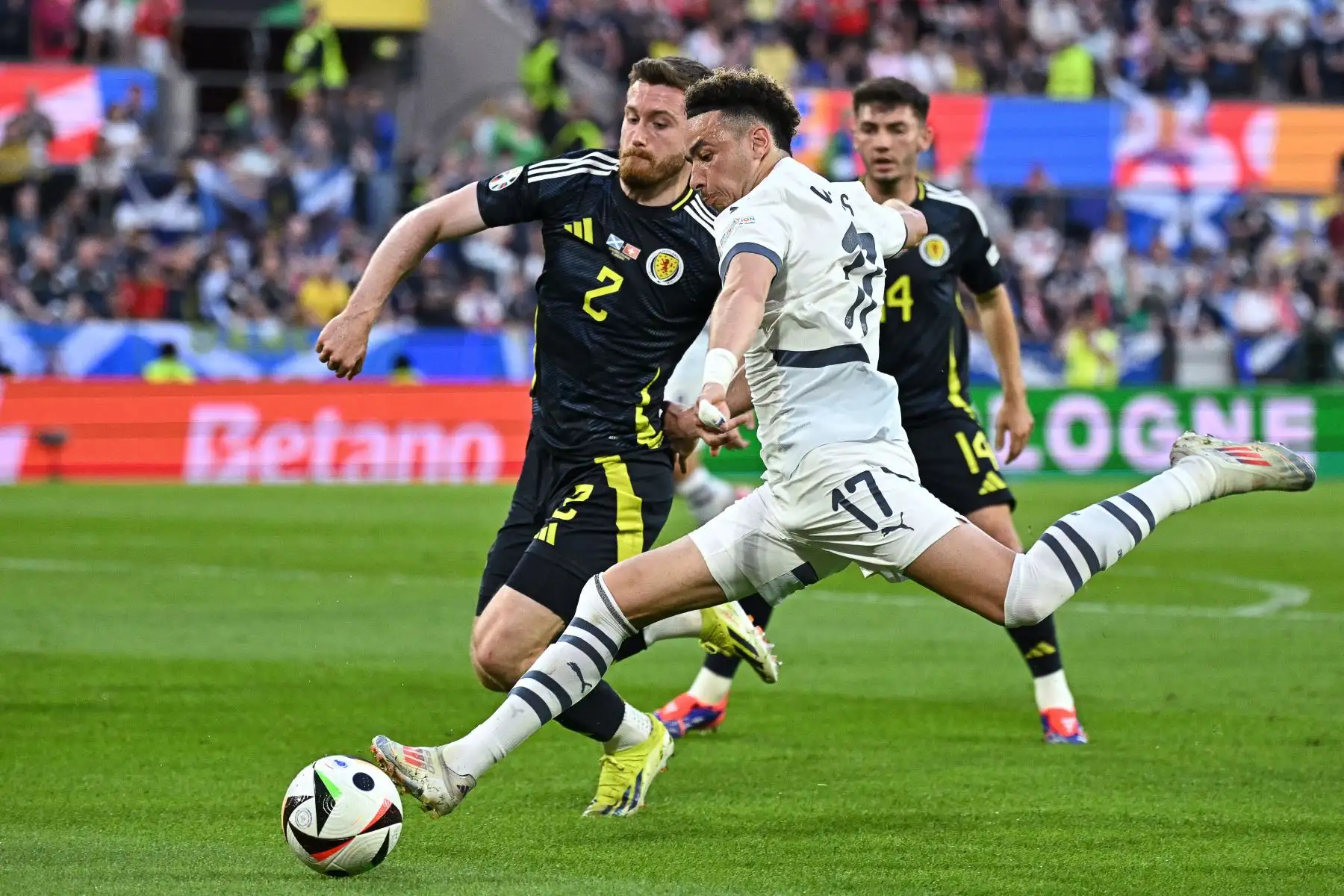 El defensor escocés Anthony Ralston  lucha por el balón con el centrocampista suizo Ruben Vargas durante el partido de fútbol del grupo A de la UEFA Euro 2024 entre Escocia y Suiza en el estadio de Colonia. Foto: ANDINA /AFP