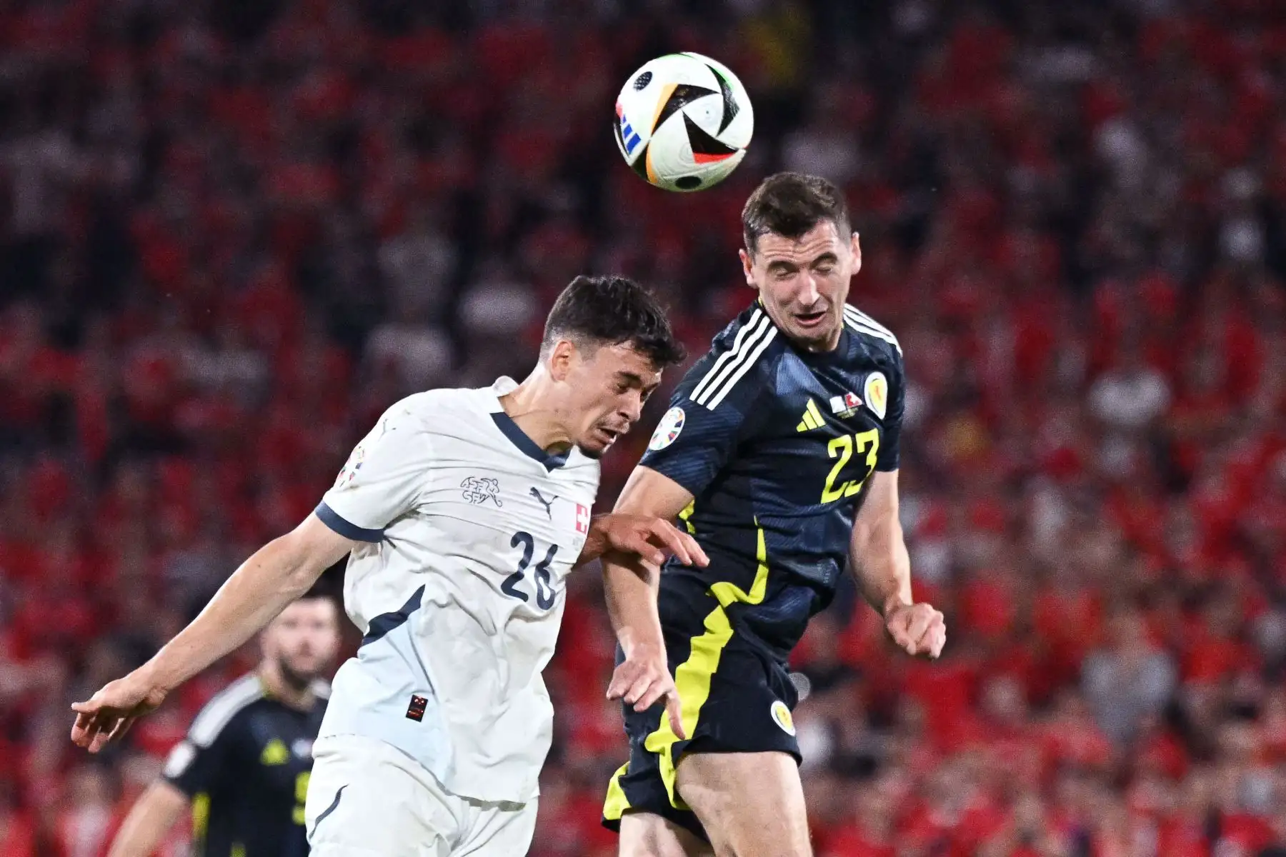 El centrocampista escocés Kenny McLean encabeza el balón junto al centrocampista suizo Fabian Rieder durante el partido de fútbol del grupo A de la UEFA Euro 2024 entre Escocia y Suiza en el estadio de Colonia. Foto: ANDINA/AFP