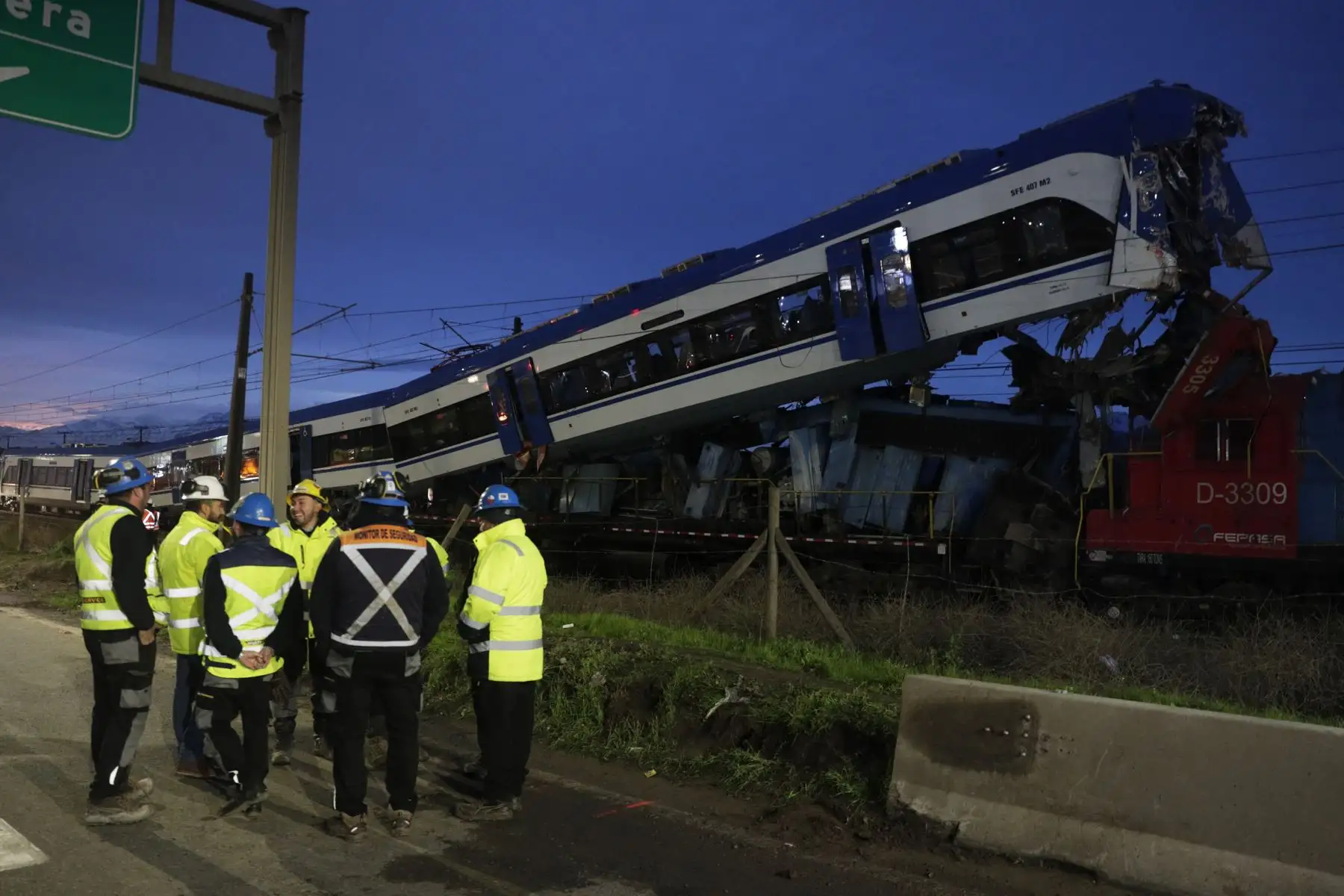 Personal de seguridad reacciona junto a las dos trenes involucrados en un accidente en la madrugada de este jueves, en la comuna de San Bernardo, en el sur de Santiago (Chile). Foto: EFE