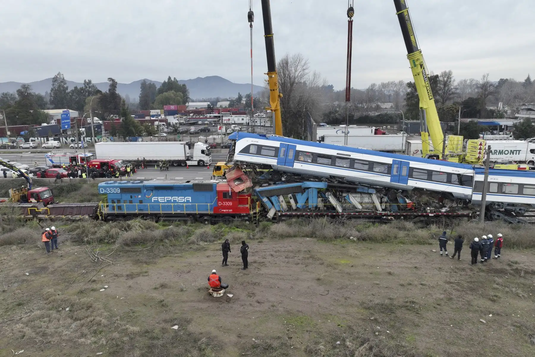 Una grúa levanta uno de los dos trenes que chocaron en la comuna de San Bernardo, en Santiago, el 20 de junio de 2024. Dos personas murieron y varias resultaron heridas tras el choque frontal entre un tren de mercancías y un tren de pruebas a primera hora de la mañana. en las afueras de la capital de Chile, informó la empresa ferroviaria. Foto: AFP