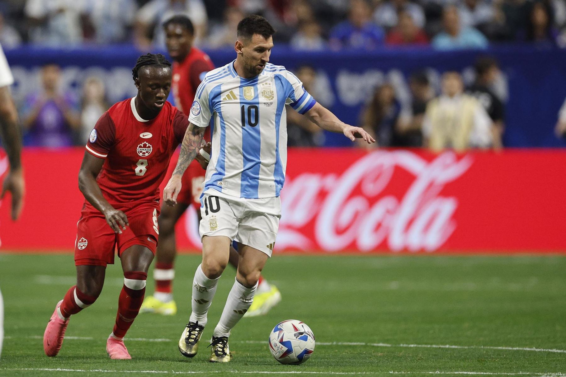 Ismael Kone de Canadá  persigue mientras Lionel Messi de Argentina  controla el balón durante la primera mitad del partido de fútbol del grupo A de la CONMEBOL Copa América 2024 entre Argentina y Canadá. EFE