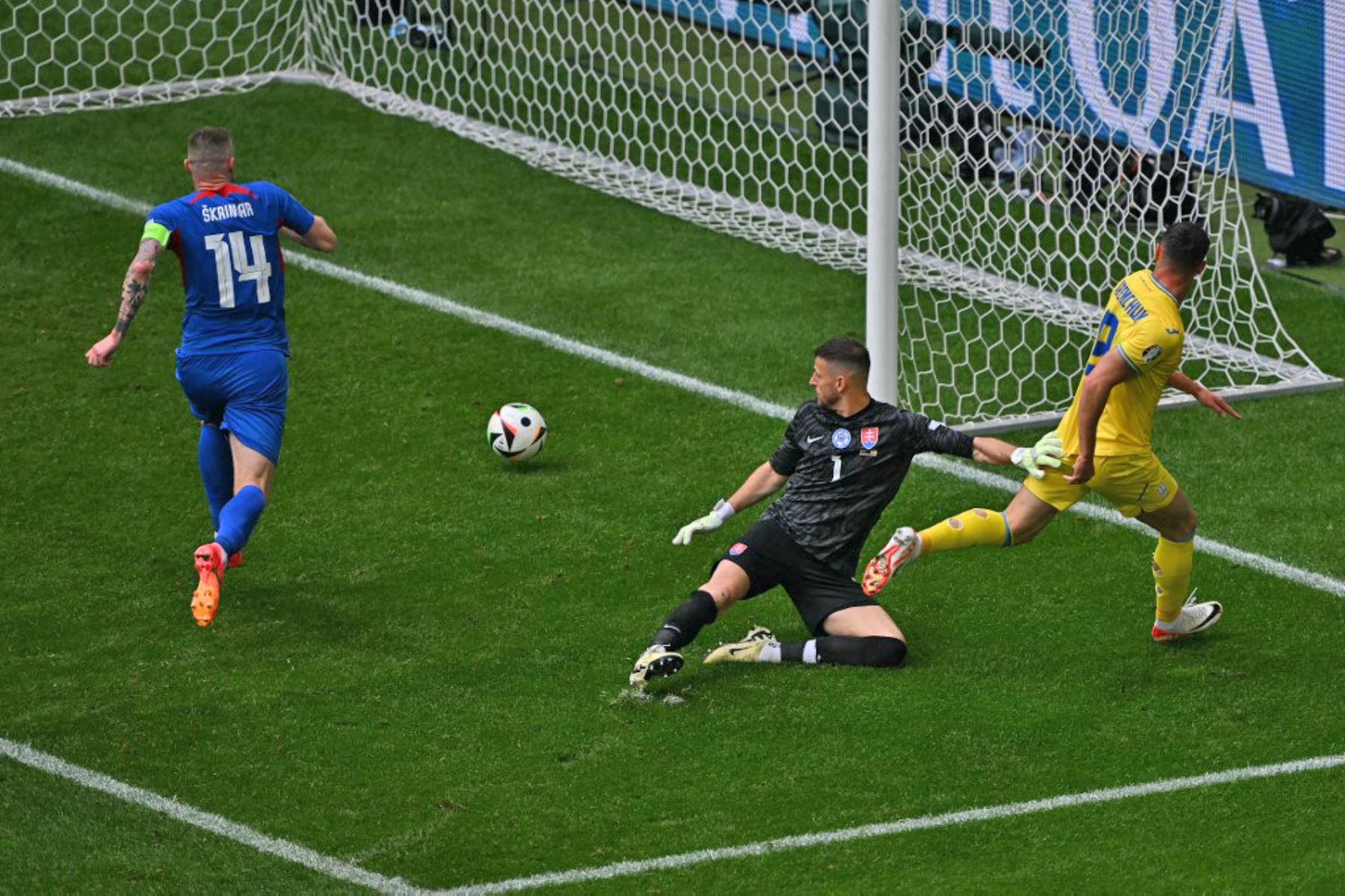 El delantero ucraniano Roman Yaremchuk anota el segundo gol de su equipo superando al portero eslovaco Martin Dubravka y al defensor eslovaco Milan Skriniar durante el partido de fútbol del Grupo E de la UEFA Euro 2024 entre Eslovaquia y Ucrania en el Duesseldorf Arena en Düsseldorf. Foto: AFP