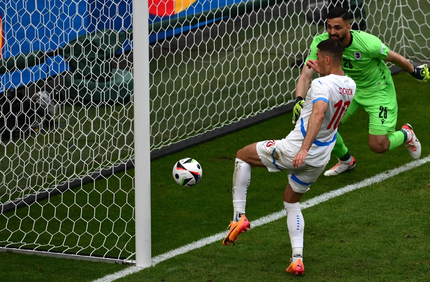 El delantero de la República Checa Patrik Schick  patea el balón para marcar el primer gol de su equipo junto al portero de Georgia  Giorgi Mamardashvili durante el partido de fútbol del Grupo F de la UEFA Euro 2024 entre Georgia y la República Checa. Foto: AFP
