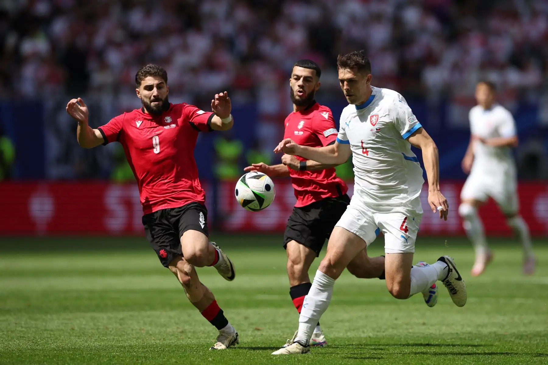 El centrocampista de Georgia  Zuriko Davitashvili  y el delantero de Georgia  Georges Mikautadze  luchan por el balón con el defensor de la República Checa  Robin Hranac durante el partido de fútbol del Grupo F de la UEFA Euro 2024 entre Georgia y la República Checa. AFP