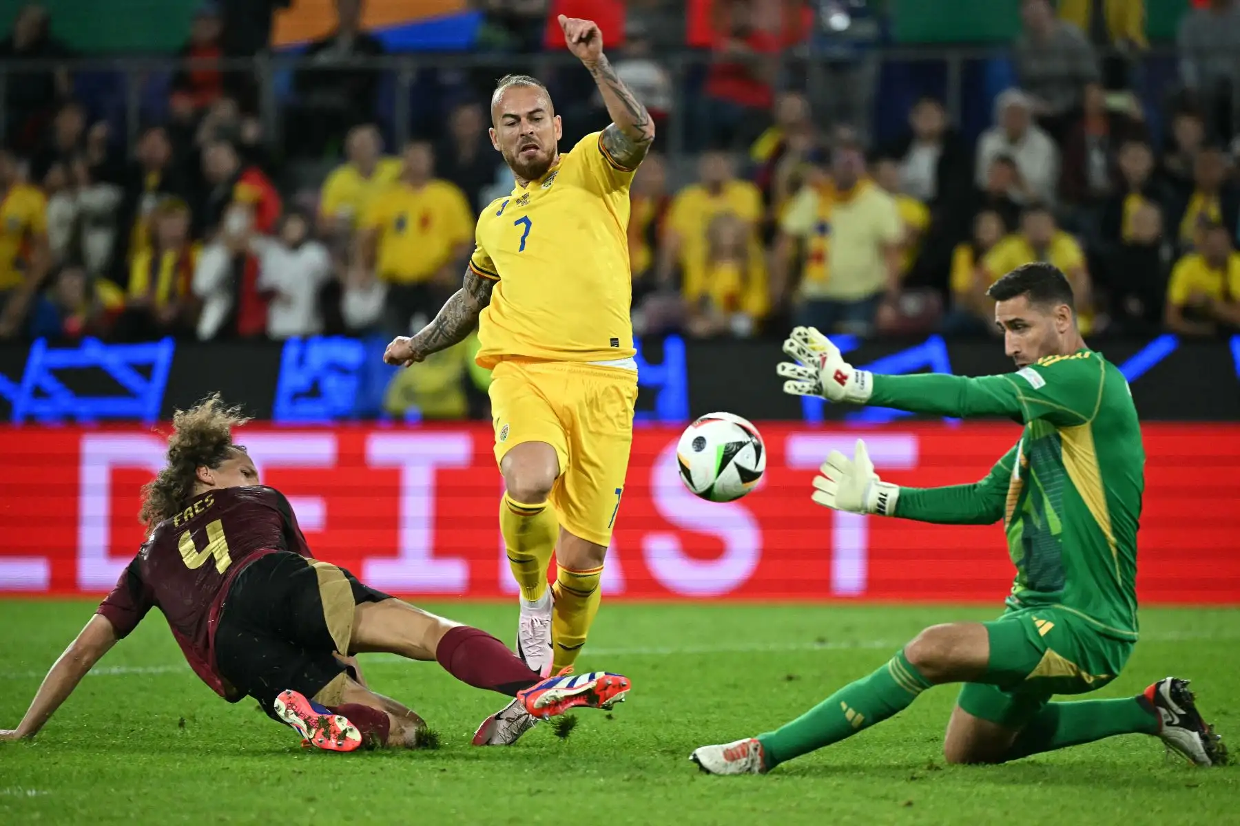 El delantero rumano Denis Alibec intenta anotar ante el portero belga  Koen Casteels y el defensor belga Wout Faes durante el partido de fútbol del Grupo E de la UEFA Euro 2024 entre Bélgica y Rumania en el estadio de Colonia.
Foto: AFP