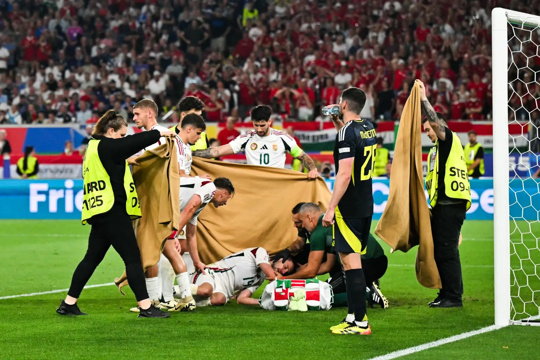 Los jugadores y los comisarios sostienen un paño mientras el delantero húngaro  Barnabas Vargas cae después de una colisión durante el partido de fútbol del Grupo A de la UEFA Euro 2024 entre Escocia y Hungría en el Stuttgart Arena en Stuttgart.
Foto: AFP