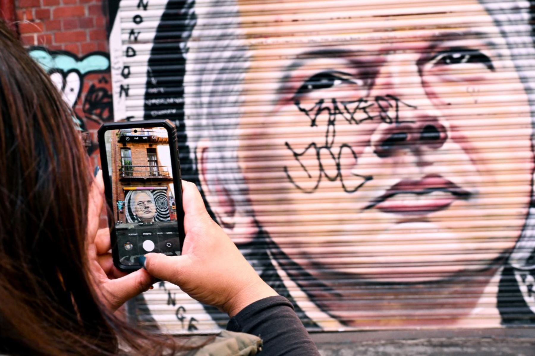 Un turista toma una foto de un mural del fundador de Wikileaks, Julian Assange, en Melbourne el 25 de junio de 2024. Foto: AFP