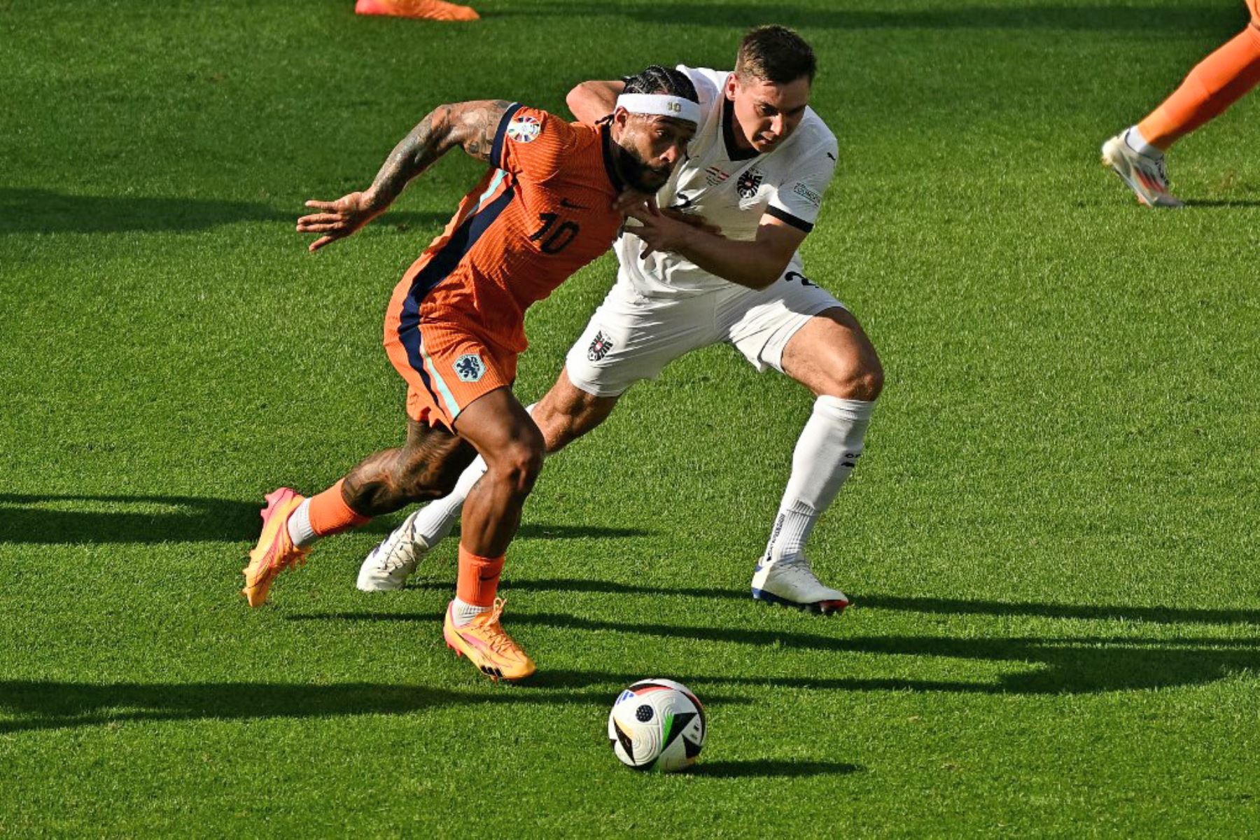 El delantero holandés Memphis Depay y el defensor austriaco Maximilian Woeber luchan por el balón durante el partido de fútbol del Grupo D de la UEFA Euro 2024 entre Holanda y Austria en el Olympiastadion de Berlín. Foto: AFP