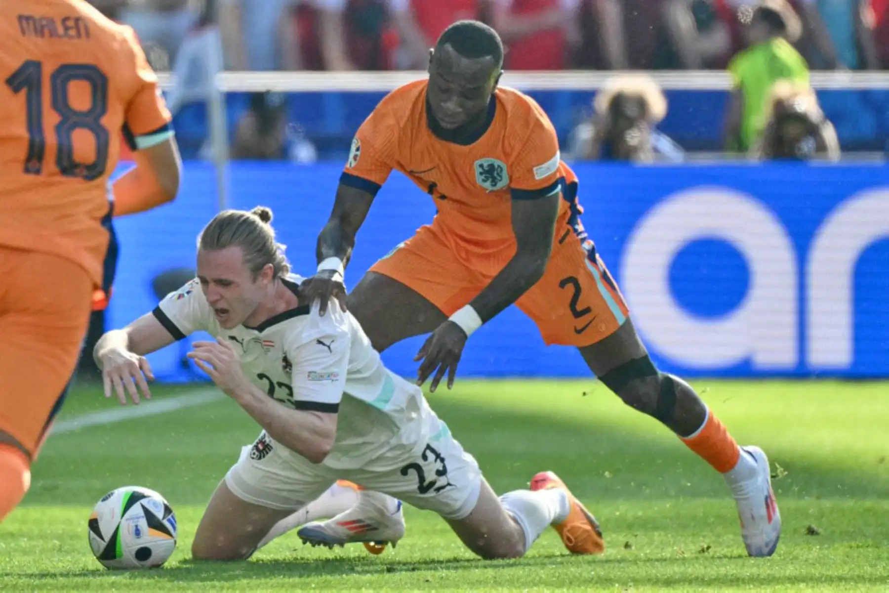 El defensor austriaco Patrick Wimmer cae en el campo junto al defensor holandés Lutsharel Geertruida durante el partido de fútbol del Grupo D de la UEFA Euro 2024 entre los Países Bajos y Austria en el Olympiastadion de Berlín.  Foto: AFP