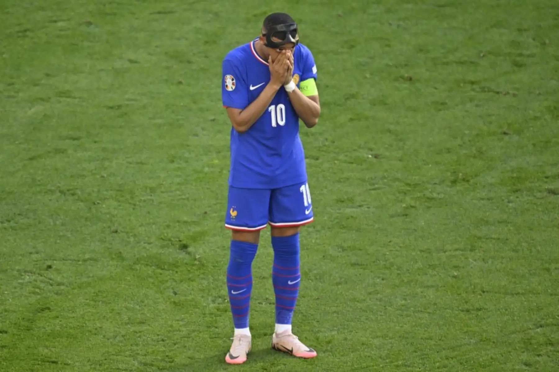 El delantero francés Kylian Mbappé se tapa la nariz después de quitarse la máscara protectora durante el partido de fútbol del Grupo D de la UEFA Euro 2024 entre Francia y Polonia en el BVB Stadion de Dortmund. Foto: AFP