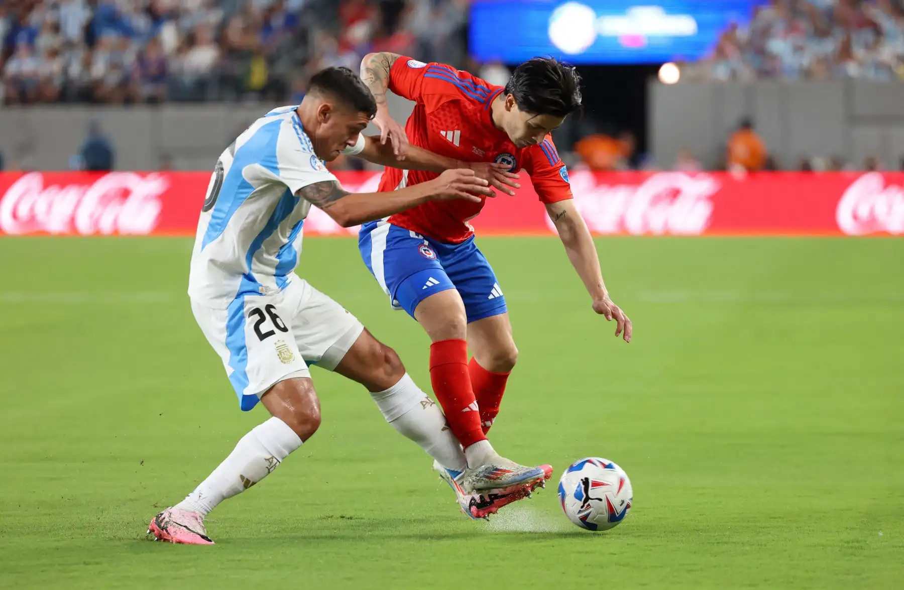 El defensor argentino Nahuel Molina Lucero y el delantero chileno Víctor Dávila compiten por el balón durante el torneo de fútbol Conmebol Copa América 2024. Un partido entre Chile y Argentina. Foto: ANDINA/AFP