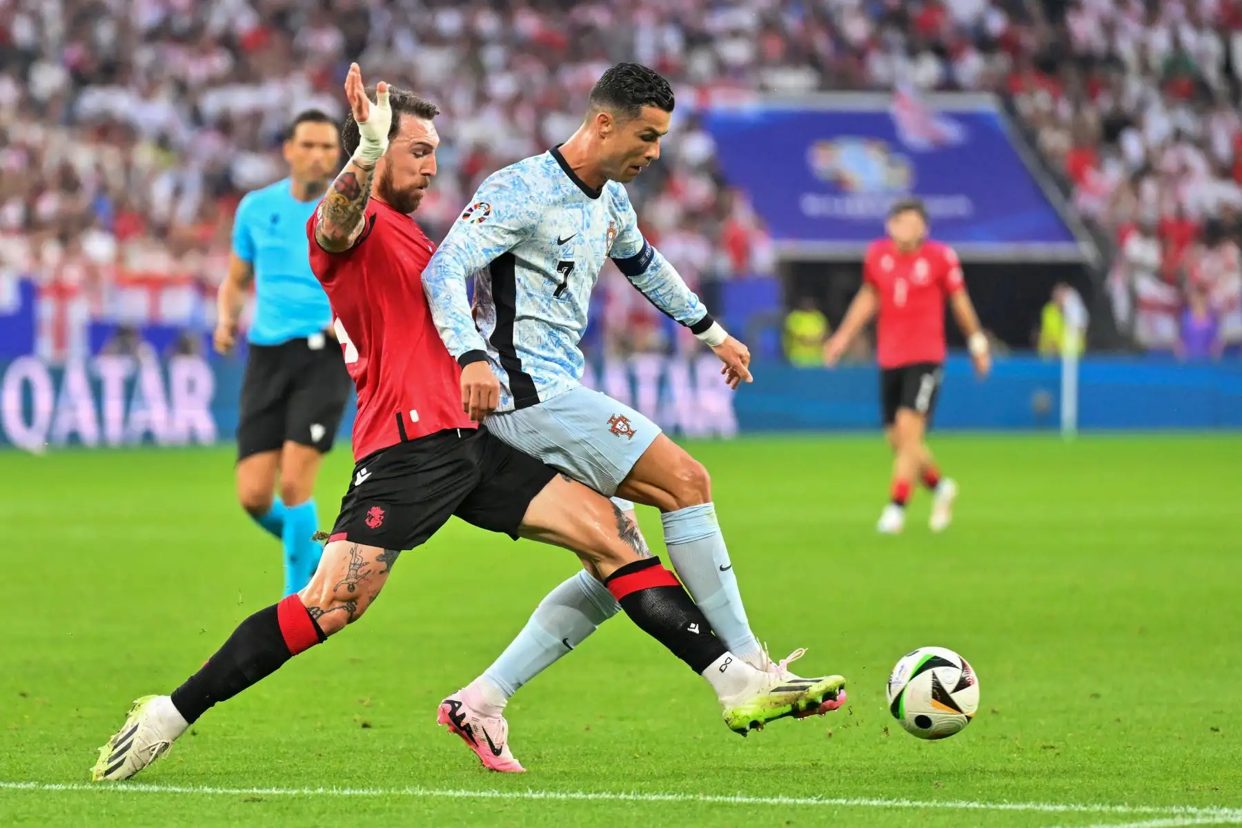 El defensor de Georgia Guram Kashia lucha por el balón con el delantero de Portugal Cristiano Ronaldo durante el partido de fútbol del Grupo F de la UEFA Euro 2024 entre Georgia y Portugal. 
Foto: ANDINA/AFP