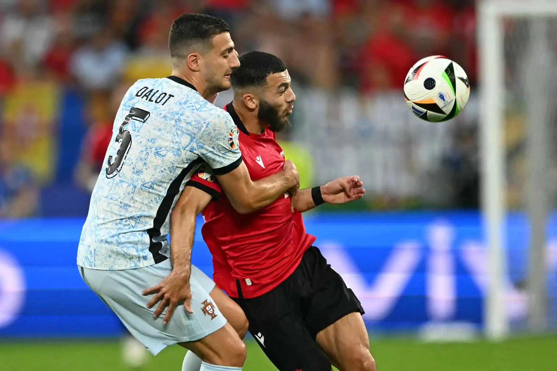El defensor de Portugal Diogo Dalot y el delantero de Georgia Georges Mikautadze compiten por el balón durante el partido de fútbol del Grupo F de la UEFA Euro 2024 entre Georgia y Portugal. Foto: ANDINA//AFP