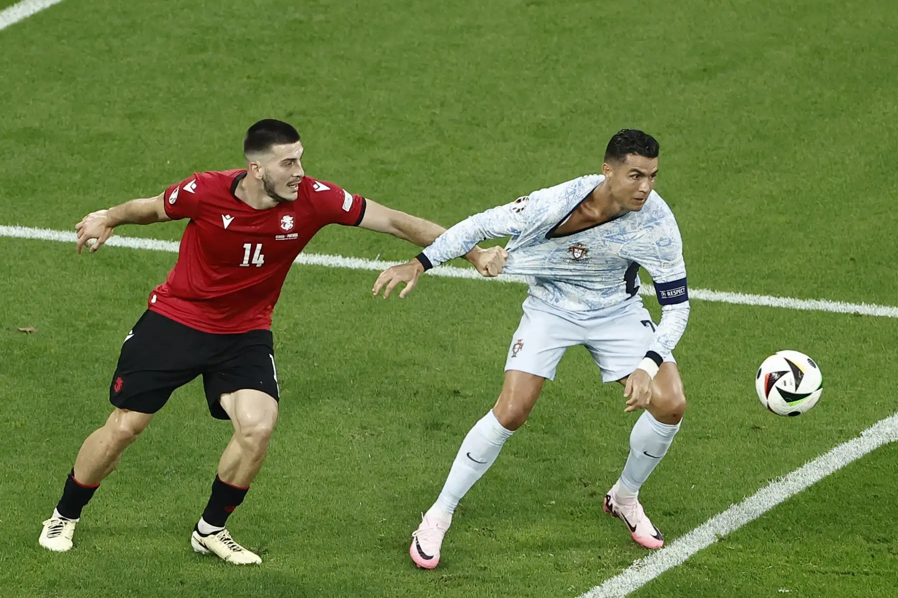 El defensor de Georgia Luka Lochoshvili sostiene la camiseta del delantero de Portugal Cristiano Ronaldo durante el partido de fútbol del Grupo F de la UEFA Euro 2024 entre Georgia y Portugal.
Foto: ANDINA/AFP