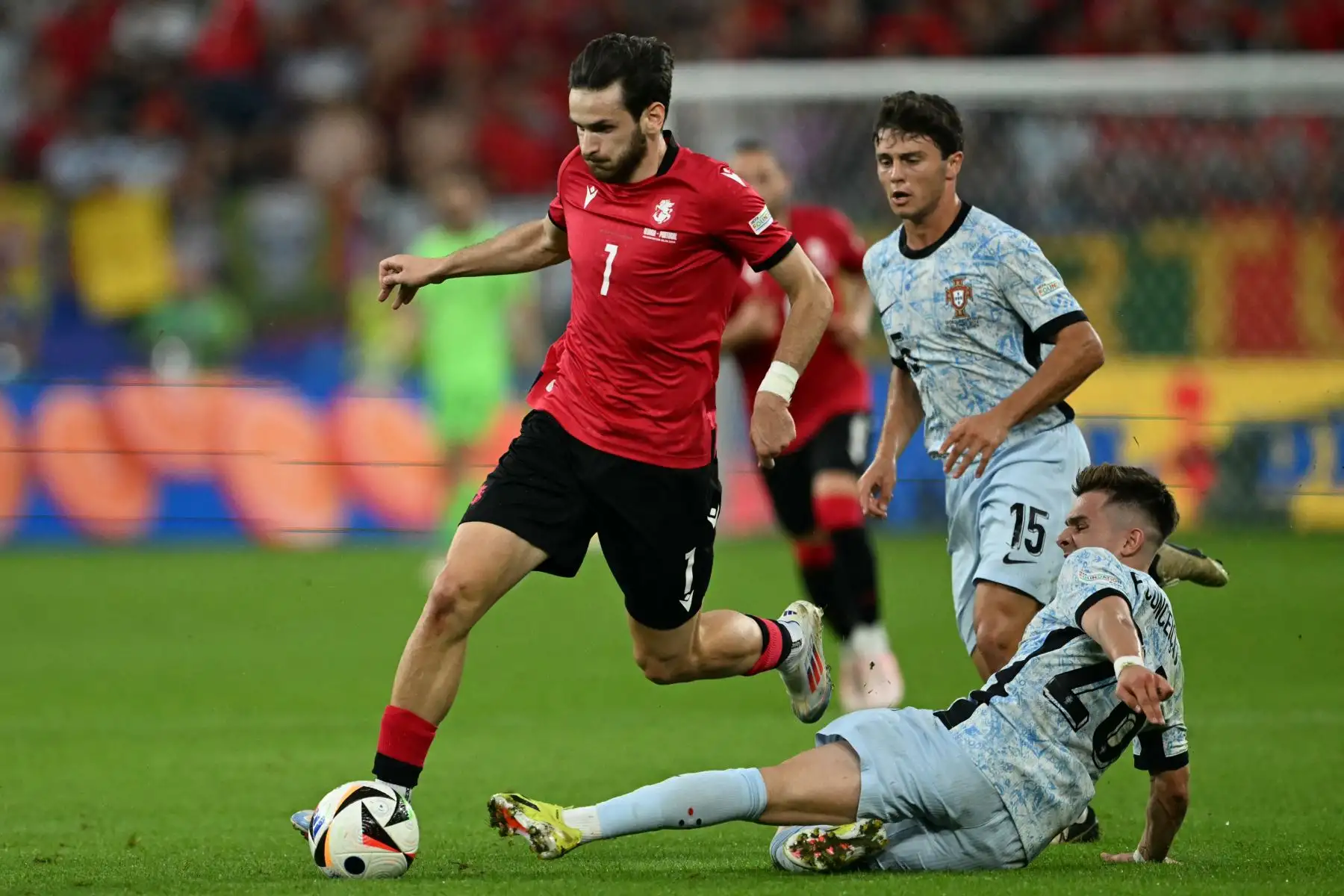 El delantero de Georgia Khvicha Kvaratskhelia compite por el balón con el delantero de Portugal Francisco Conceicao y el centrocampista de Portugal Joao Neves durante el partido de fútbol del Grupo F de la UEFA Euro 2024 entre Georgia y Portugal. Foto: ANDINA/AFP