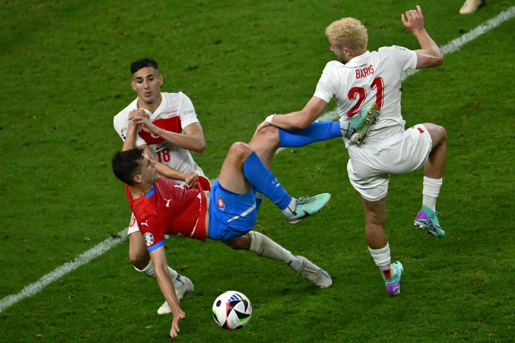 El delantero de Turquía Baris Alper Yilmaz y el defensor de la República Checa Robin Hranac luchan por el balón junto al defensor de Turquía  Mert Muldur durante el partido de fútbol del Grupo F de la UEFA Euro 2024 entre la República Checa y Turquía. Foto: ANDINA/AFP