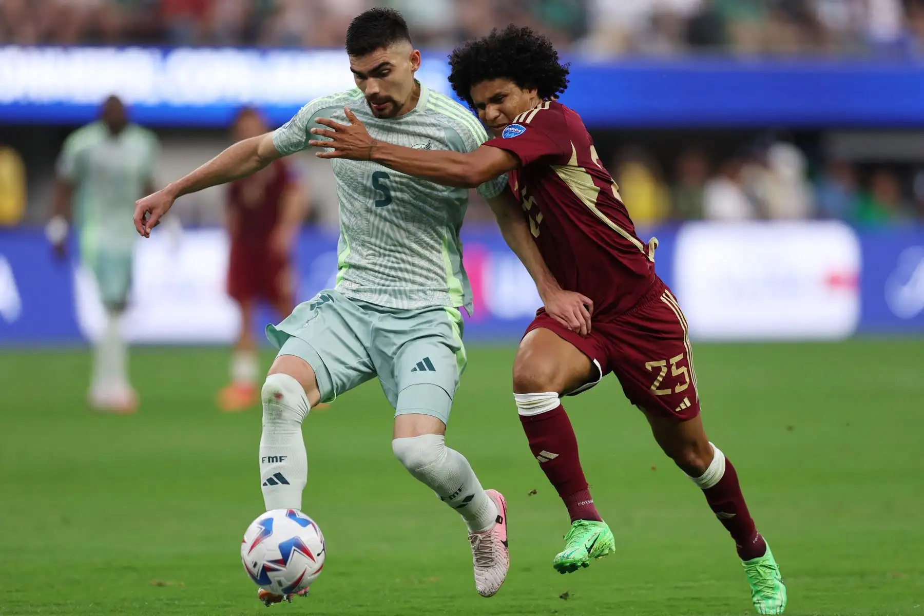 Johan Vásquez de México lucha por la posesión con Eduard Bello de Venezuela durante el partido del Grupo B de la CONMEBOL Copa América 2024 entre Venezuela y México. Foto: ANDINA/AFP