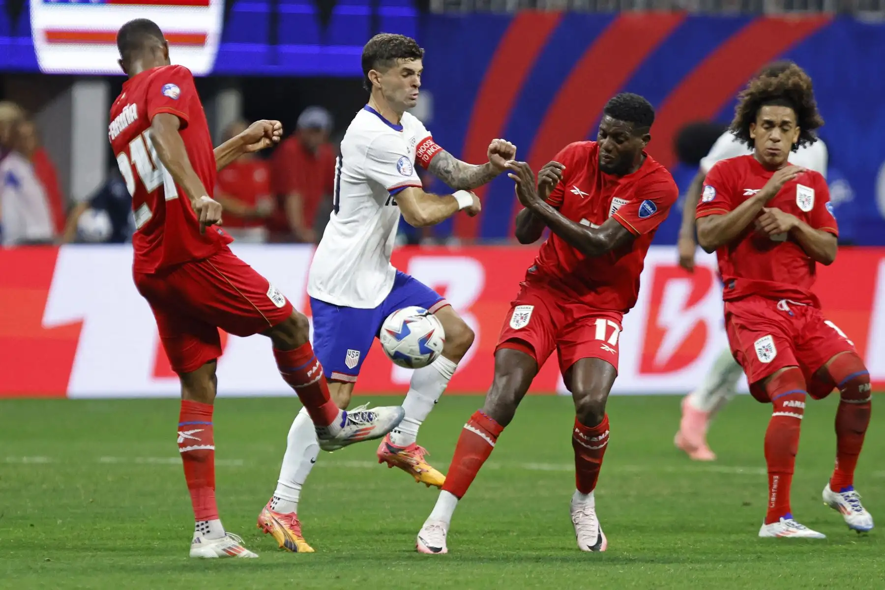 El delantero estadounidense Christian Pulisic lucha por el balón con el defensor panameño Edgardo Farina y el delantero panameño  José Fajardo durante el partido de fútbol del grupo C del torneo Conmebol Copa América 2024 entre Panamá y Estados Unidos. Foto: ANDINA/AFP