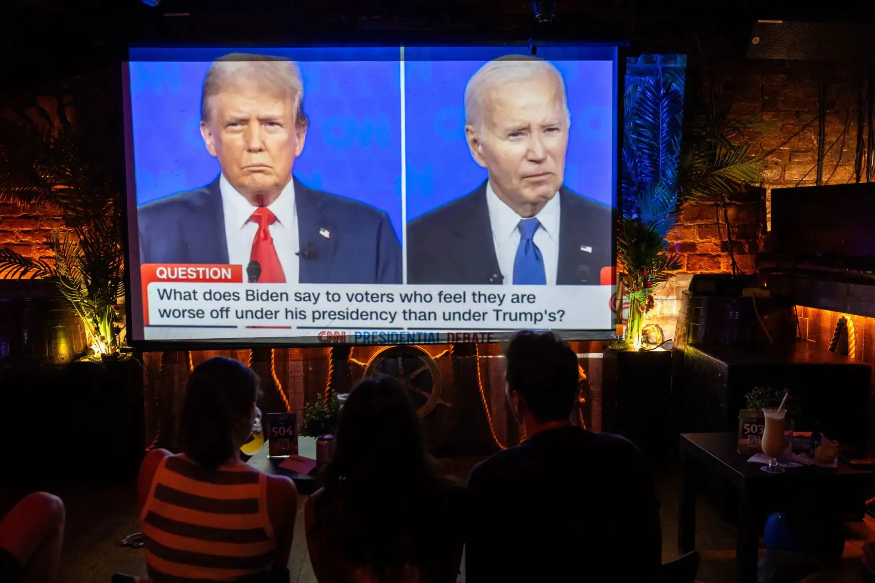 La gente observa el debate presidencial entre el presidente estadounidense Joe Biden y el presunto candidato republicano, el ex presidente Donald Trump. Foto: ANDINA/AFP