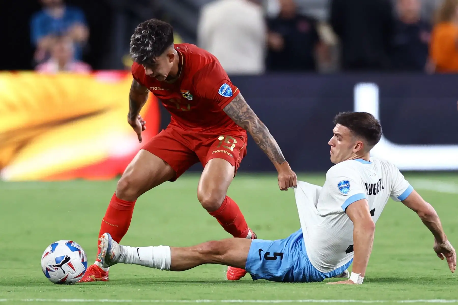 Gabriel Villamil de Bolivia y Manuel Ugarte de Uruguay luchan por el balón durante el partido del Grupo C de la CONMEBOL Copa América 2024 entre Uruguay y Bolivia. Foto: ANDINA/ AFP