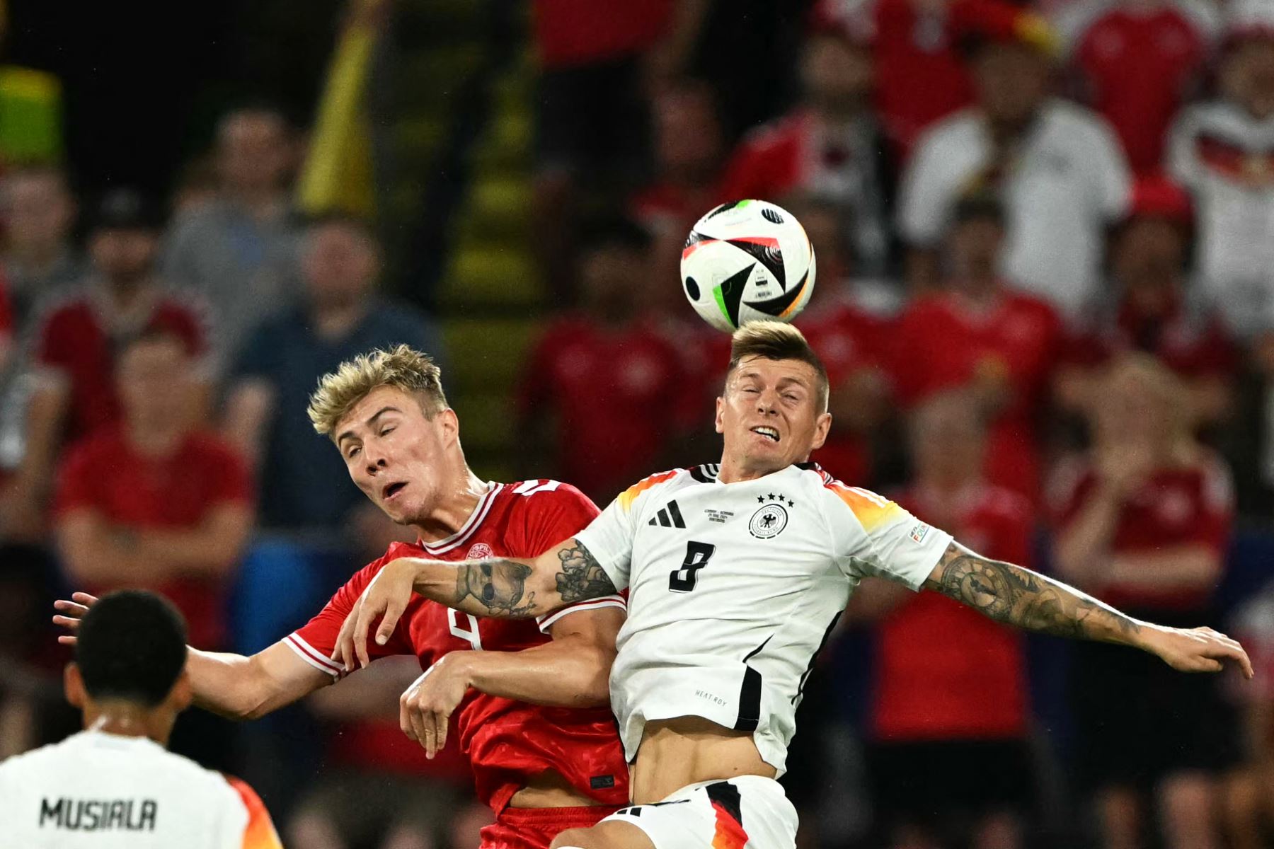 El delantero danés Rasmus Hojlund y el centrocampista alemán  Toni Kroos saltan al balón durante el partido de fútbol de octavos de final de la UEFA Euro 2024 entre Alemania y Dinamarca. AFP