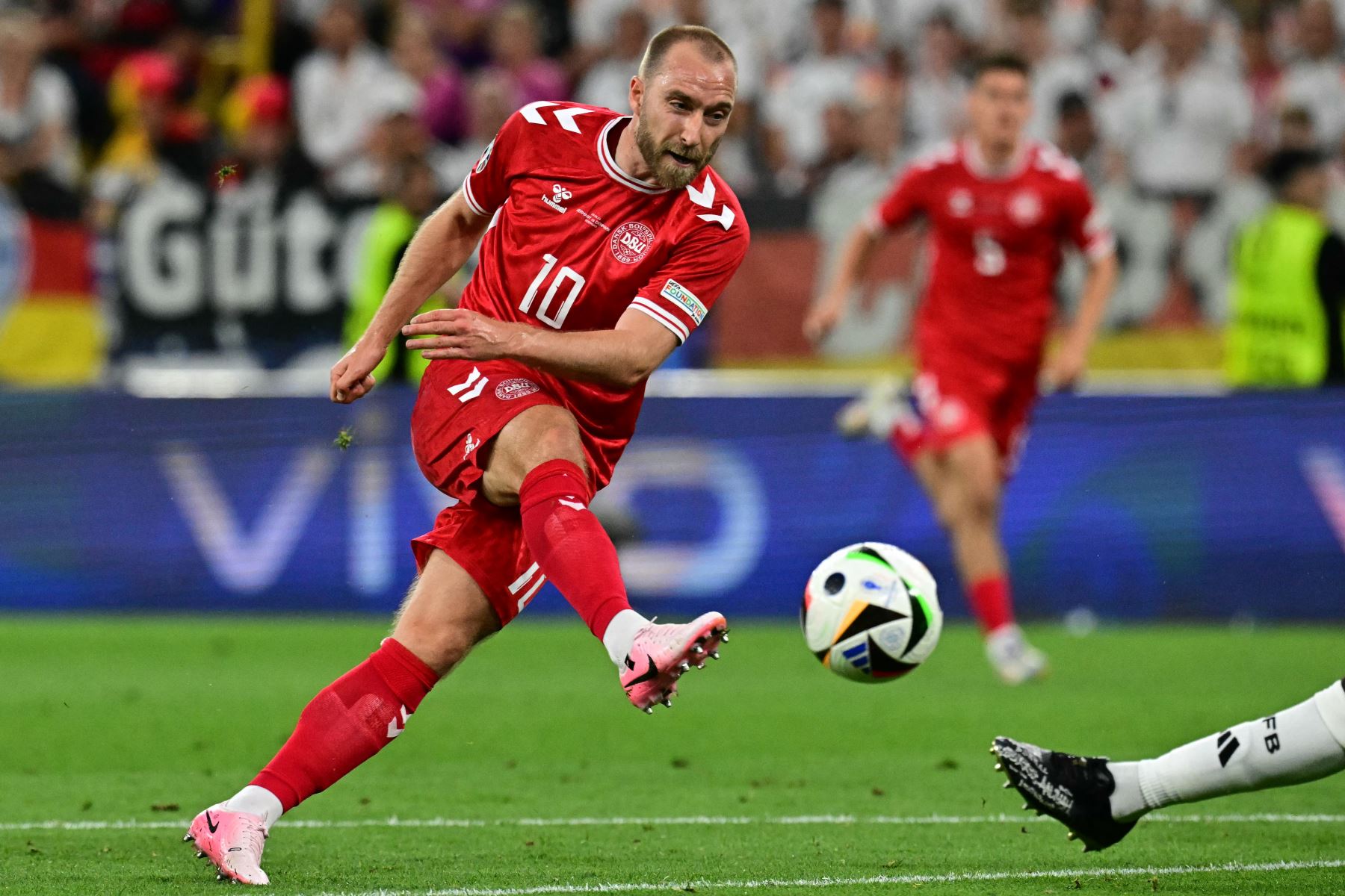 El centrocampista danés  Christian Eriksen dispara pero no logra anotar durante el partido de fútbol de octavos de final de la UEFA Euro 2024 entre Alemania y Dinamarca. AFP