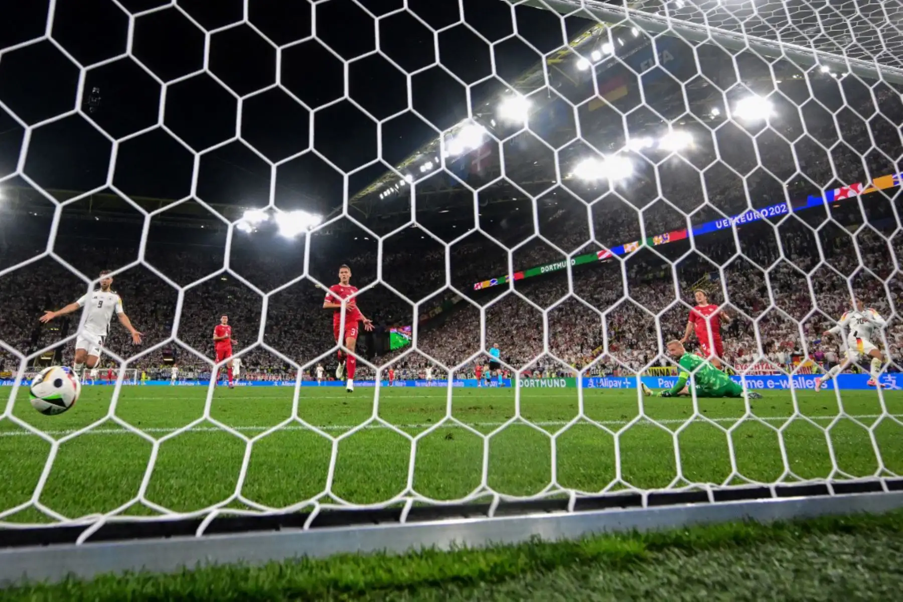 El centrocampista alemán Jamal Musiala anota el segundo gol de su equipo superando al portero danés Kasper Schmeichel durante el partido de octavos de final de la UEFA Euro 2024 entre Alemania y Dinamarca. Foto: AFP