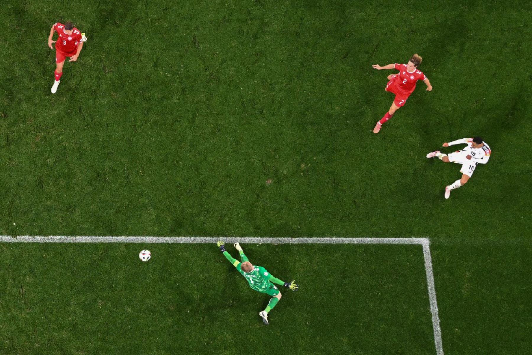 El centrocampista alemán Jamal Musiala anota el segundo gol de su equipo superando al portero danés Kasper Schmeichel durante el partido de octavos de final de la UEFA Euro 2024 entre Alemania y Dinamarca. Foto: AFP