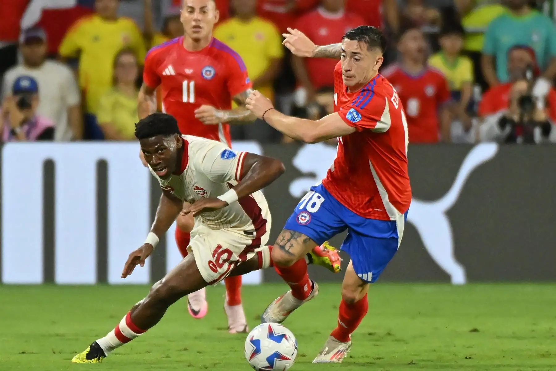 Jonathan David de Canadá desafía el balón con Rodrigo Echeverría de Chile durante el partido del Grupo A de la CONMEBOL Copa América 2024 entre Canadá y Chile en el Estadio Exploria.
Foto: AFP