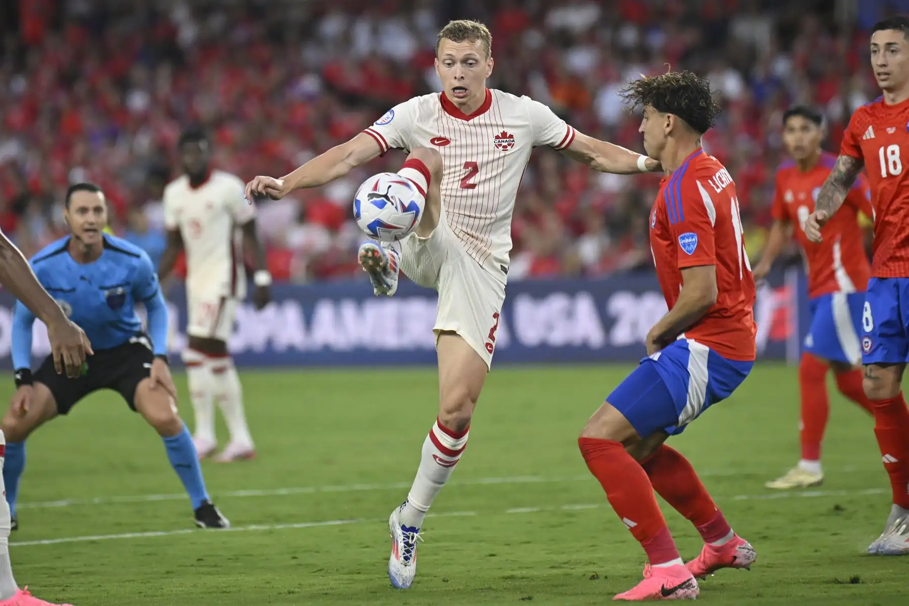 Alistair Johnston de Canadá en acción contra el chileno Igor Lichnovsky durante un partido del grupo A de la CONMEBOL Copa América en Orlando, Florida (EE.UU.).
Foto : EFE
