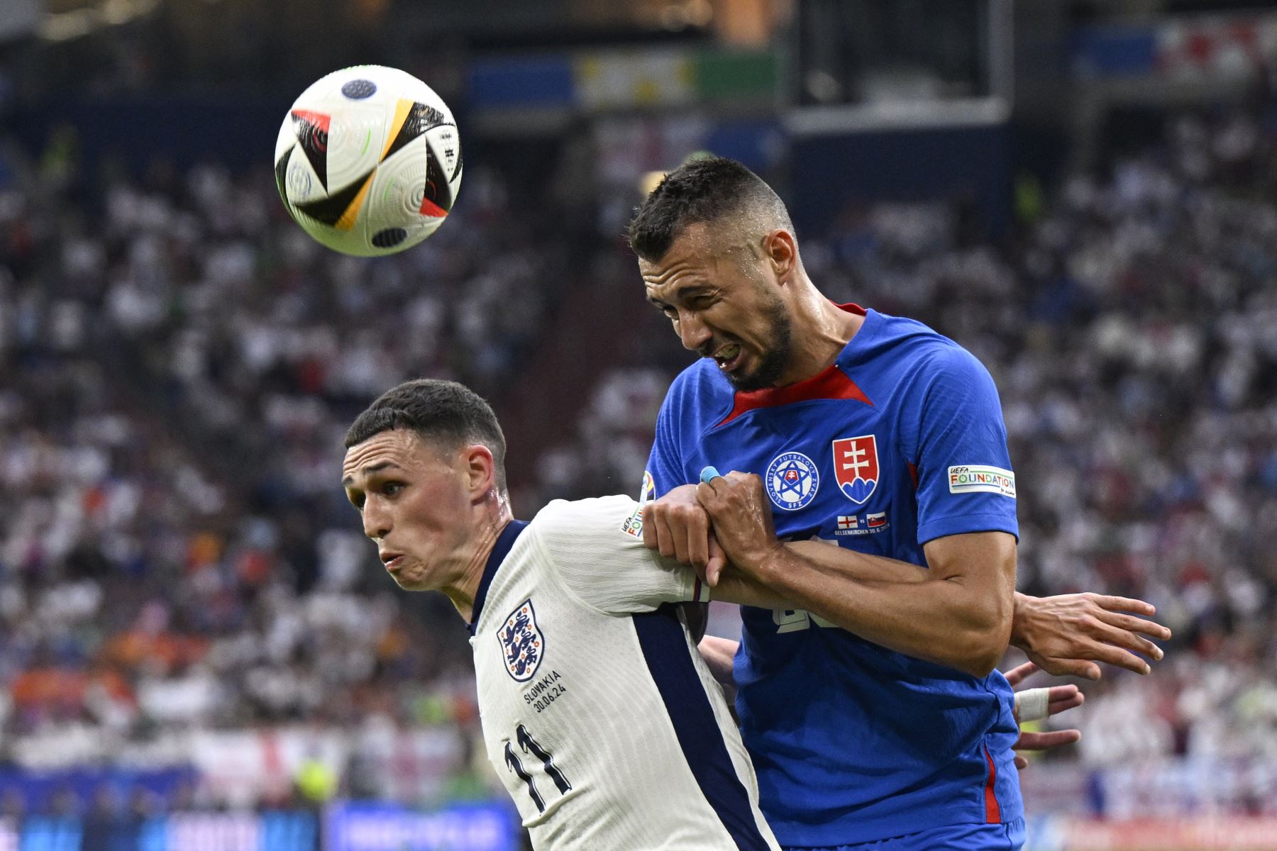 El centrocampista de Inglaterra Phil Foden y el delantero de Eslovaquia Ivan Schranz luchan por el balón durante el partido de fútbol de octavos de final de la UEFA Euro 2024 entre Inglaterra y Eslovaquia. AFP