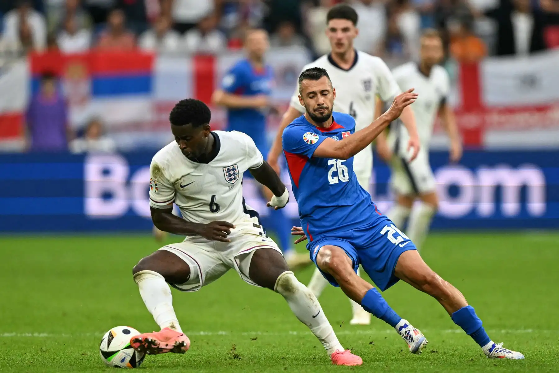 El defensor de Inglaterra  Marc Guehi  trabaja alrededor del delantero de Eslovaquia Ivan Schranz durante el partido de fútbol de octavos de final de la UEFA Euro 2024 entre Inglaterra y Eslovaquia. AFP