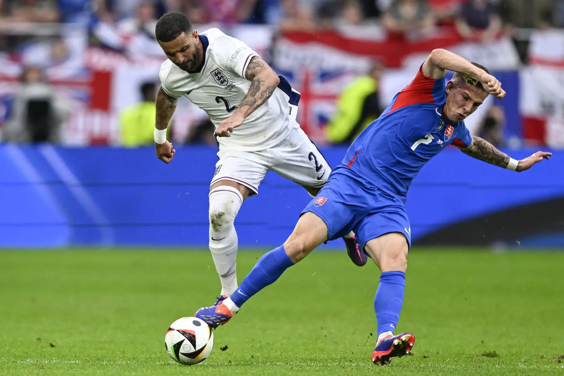 El defensor de Inglaterra  Kyle Walker y el delantero de Eslovaquia  Tomas Suslov luchan por el balón durante el partido de fútbol de octavos de final de la UEFA Euro 2024 entre Inglaterra y Eslovaquia. AFP