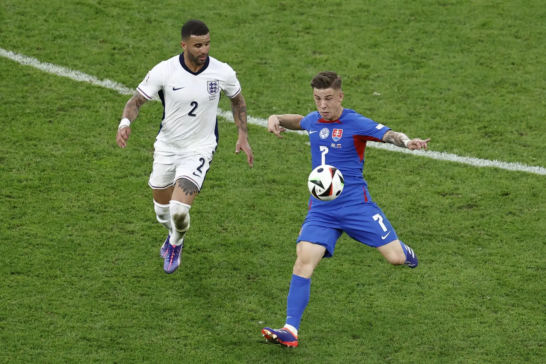 El defensor de Inglaterra  Kyle Walker y el delantero de Eslovaquia  Tomas Suslov luchan por el balón durante el partido de fútbol de octavos de final de la UEFA Euro 2024 entre Inglaterra y Eslovaquia. AFP