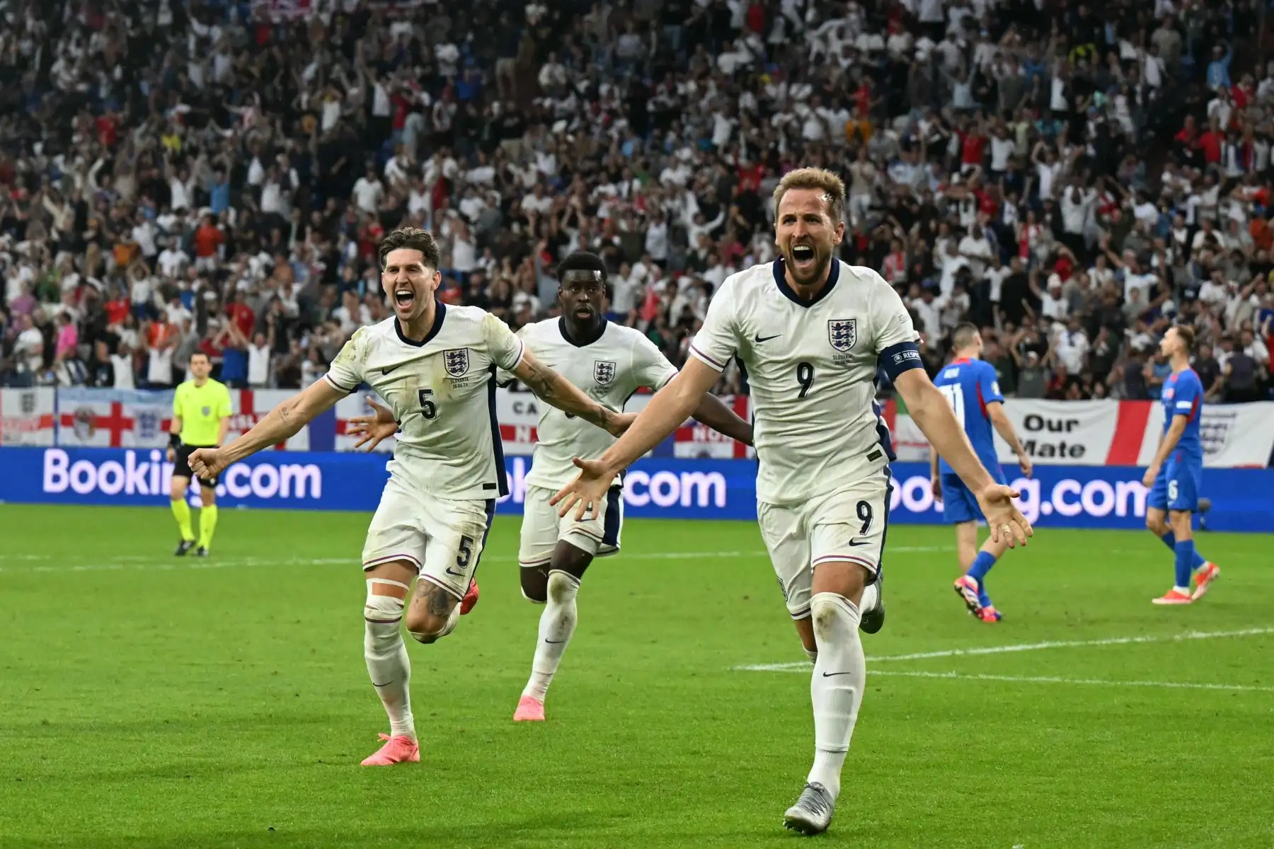 El defensor de Inglaterra  John Stones, el defensor de Inglaterra Marc Guehi y el delantero de Inglaterra  Harry Kane celebran después de que Kane celebra el segundo gol de su equipo durante el partido de fútbol de octavos de final de la UEFA Euro 2024 entre Inglaterra y Eslovaquia. AFP