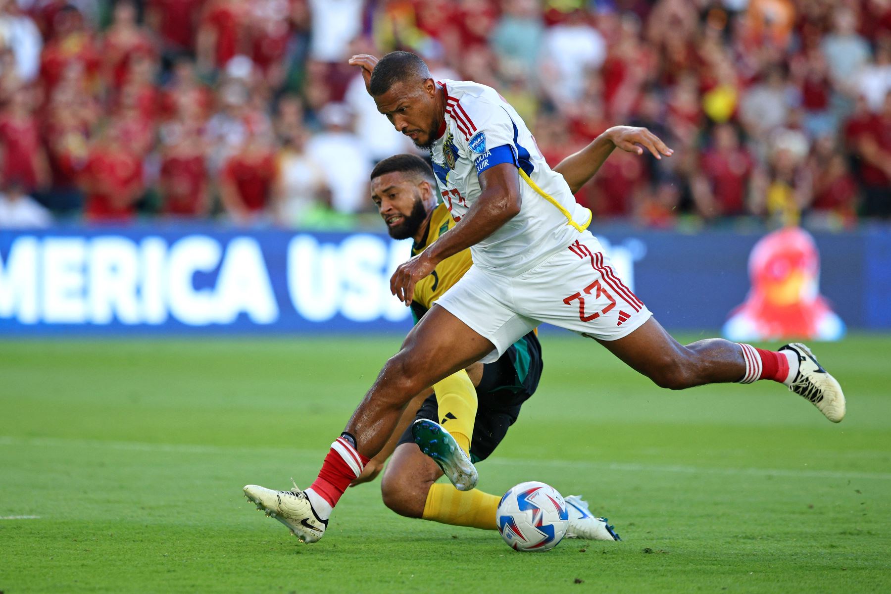 El delantero de Venezuela Salomon Rondon anota el segundo gol de su equipo mientras lucha por el balón con el defensor de Jamaica  Michael Hector durante el partido de fútbol del grupo B del torneo Copa América Conmebol 2024 entre Jamaica y Venezuela.
Foto: AFP