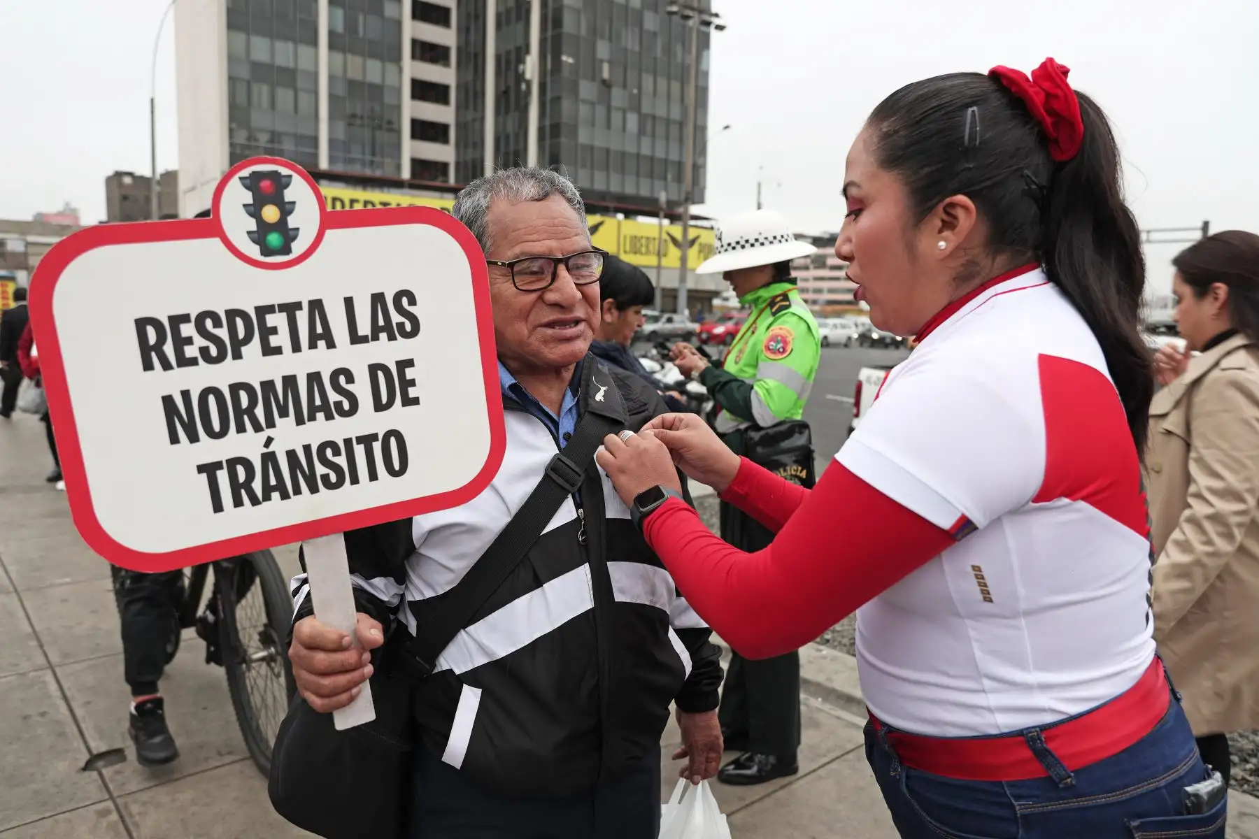 Iniciando el mes patrio, policía peruana coloca una escarapela a ciudadano  muy temprano por la mañana. Foto: ANDINA/ Connie Calderon