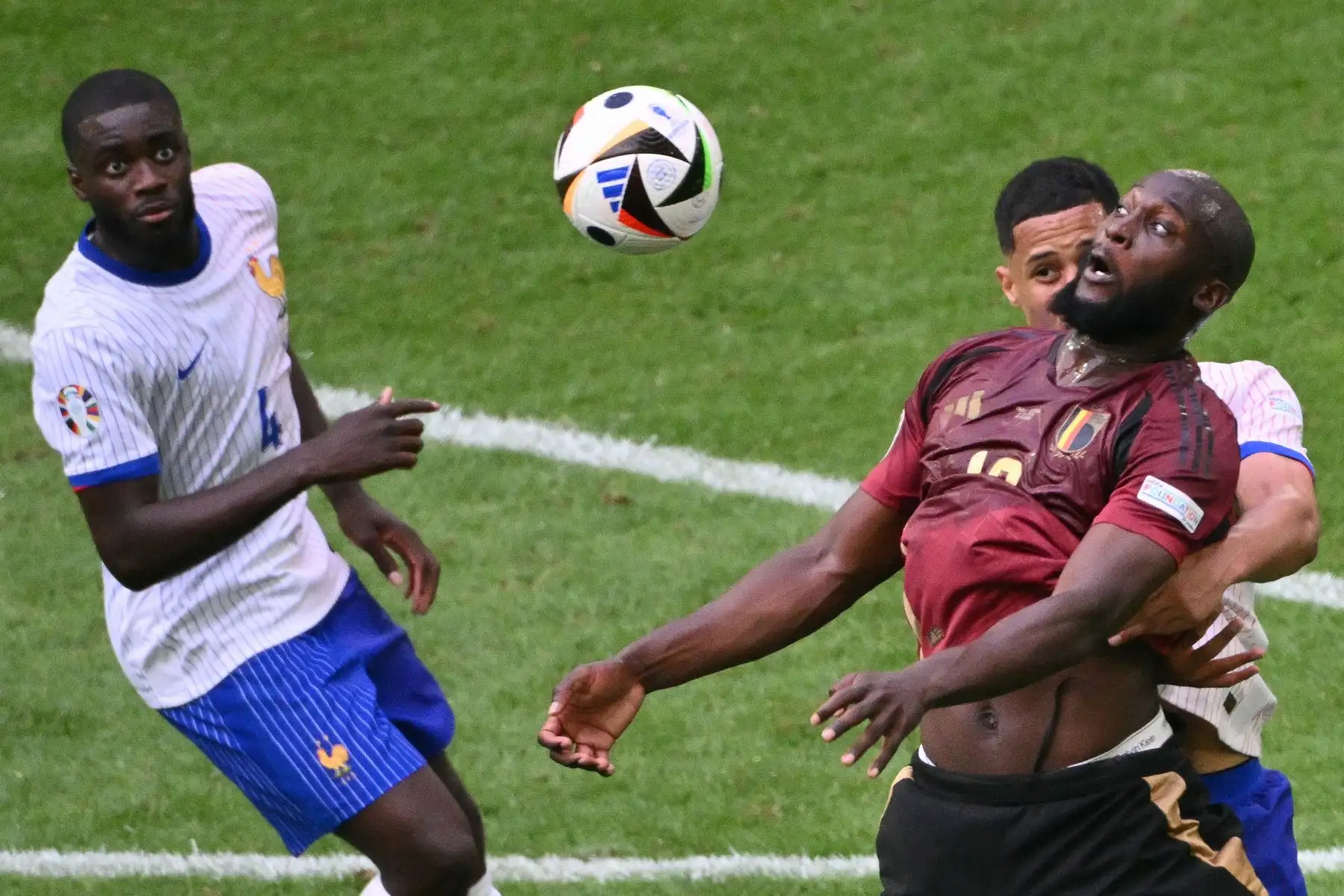 El defensor francés Dayot Upamecano observa cómo el defensor francés  William Saliba y el delantero belga Romelu Lukaku saltan al balón durante el partido de octavos de final de la UEFA Euro 2024 entre Francia y Bélgica en el Duesseldorf Arena.
Foto: AFP