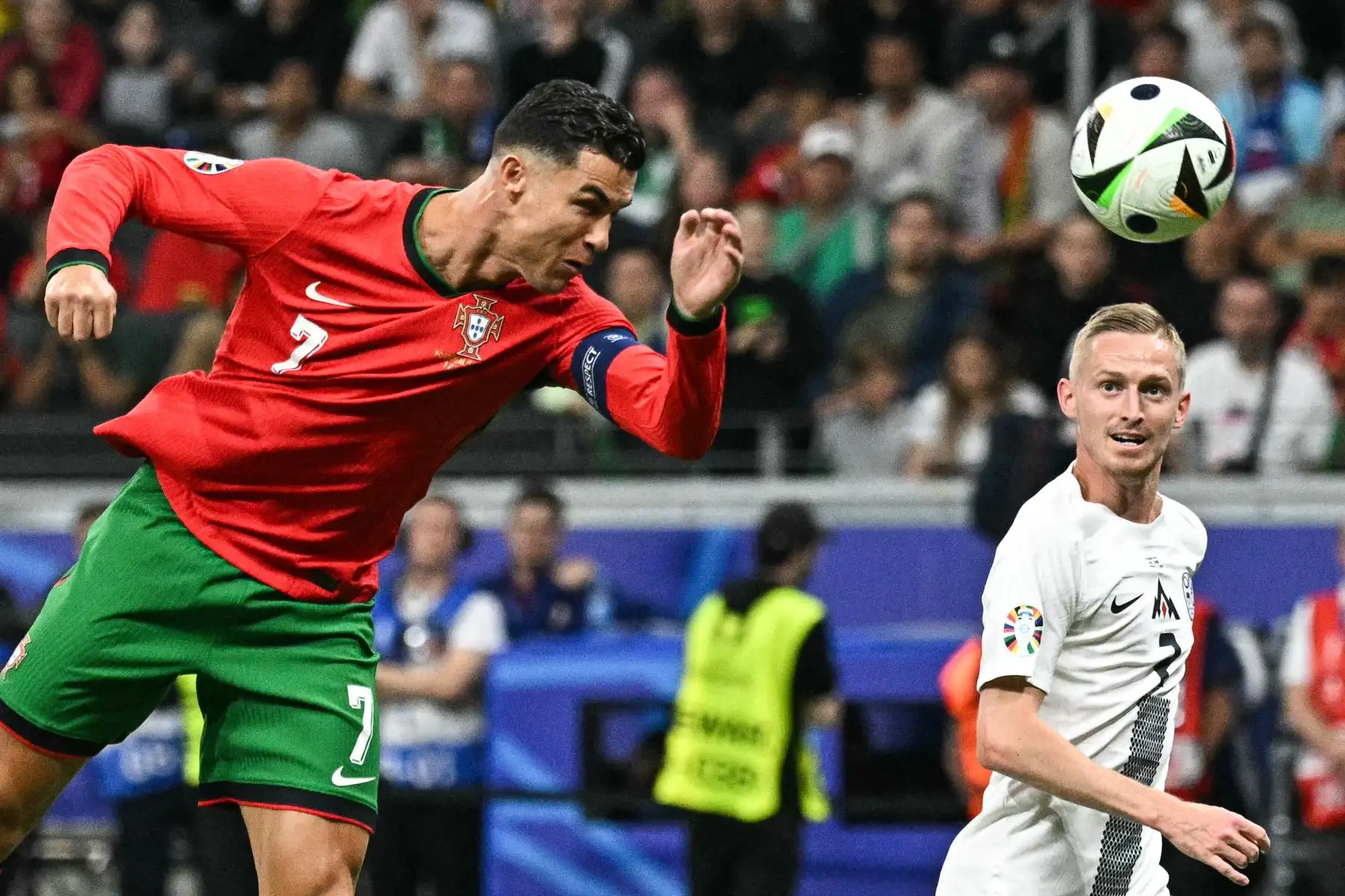 El delantero portugués, Cristiano Ronaldo, dirige el balón al defensor esloveno, Zan Karnicnik, durante el partido de octavos de final de la UEFA Euro 2024 entre Portugal y Eslovenia en el Frankfurt Arena de Frankfurt am Main el 1 de julio de 2024. Foto: AFP