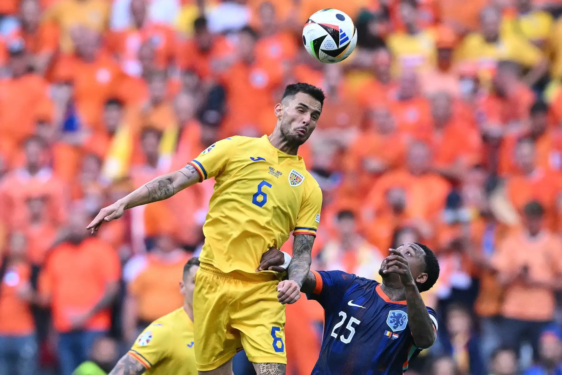 El centrocampista rumano  Marius Marin encabeza el balón por delante del delantero holandés  Steven Bergwijn durante el partido de fútbol de octavos de final de la UEFA Euro 2024 entre Rumania y Holanda en el Munich Football Arena en Munich.
Foto: AFP