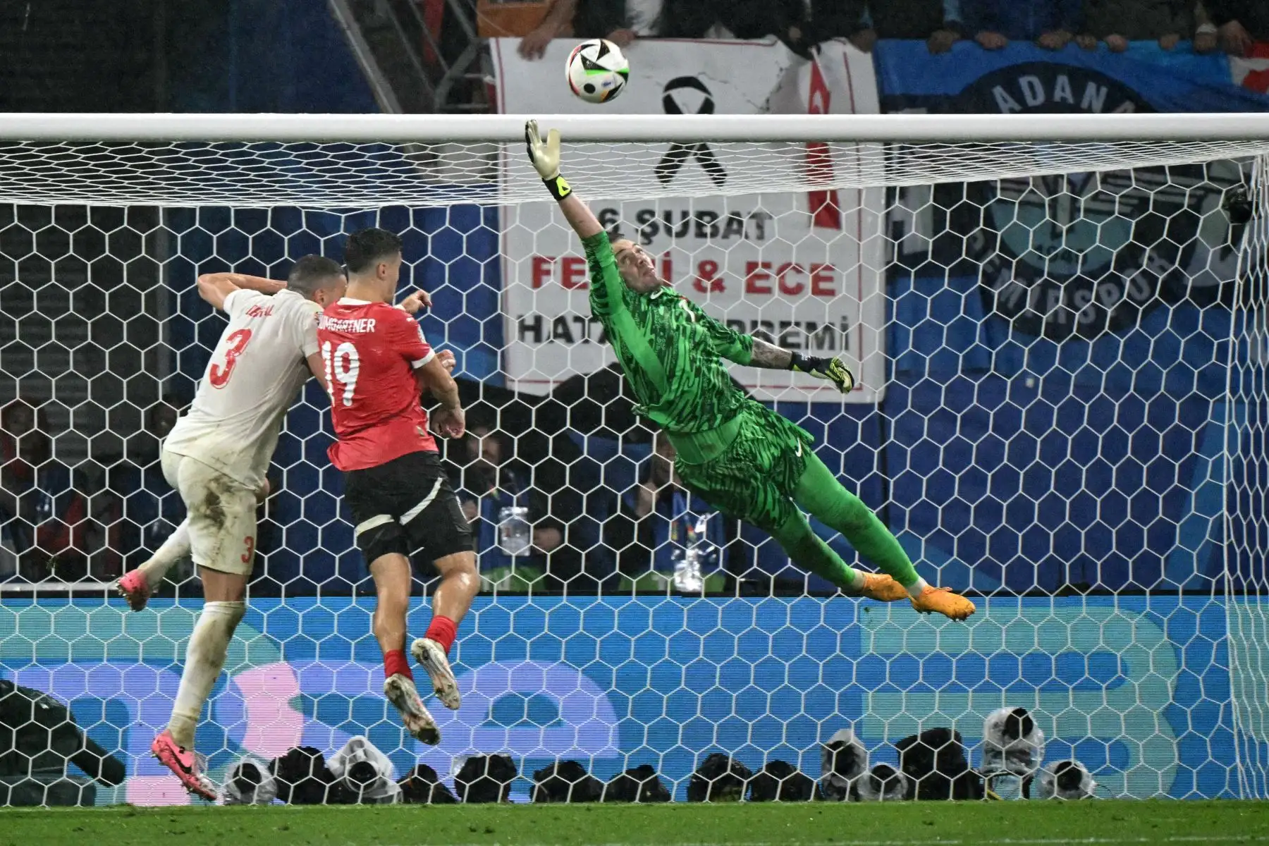El mediocampista austriaco Christoph Baumgartner encabeza el balón mientras el portero turco Mert Gunok salta para bloquearlo durante el partido de octavos de final de la UEFA Euro 2024 entre Austria y Turquía. Foto: ANDINA/AFP